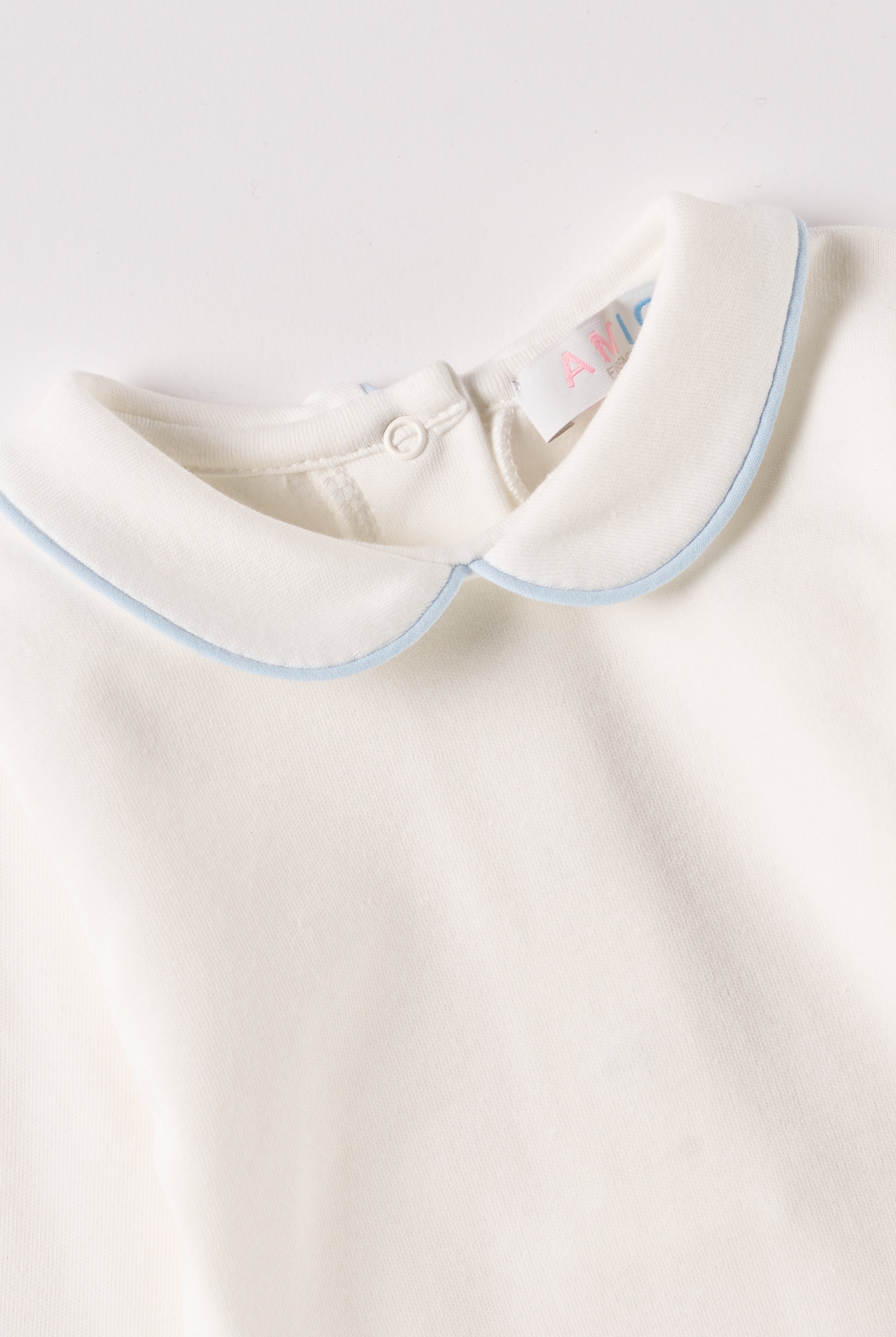 Der langarmige Body, gefertigt aus 100% Baumwolle, hat eine perfekte Passform. Kundinnen und Kunden vertrauen auf unseren Schnitt, da die flachen Druckknöpfe an der Rückseite ein unkompliziertes und schnelles Anziehen ermöglichen. Die "flanellartige" Innenseite wurde speziell für zarte Kinderhaut konzipiert und bietet ein besonders sanftes Trageerlebnis. Ein großer Vorteil der flanellartigen Innenseite ist, dass die Kinder weniger schwitzen. Der Kragen verleiht dem Body ein edles Design.