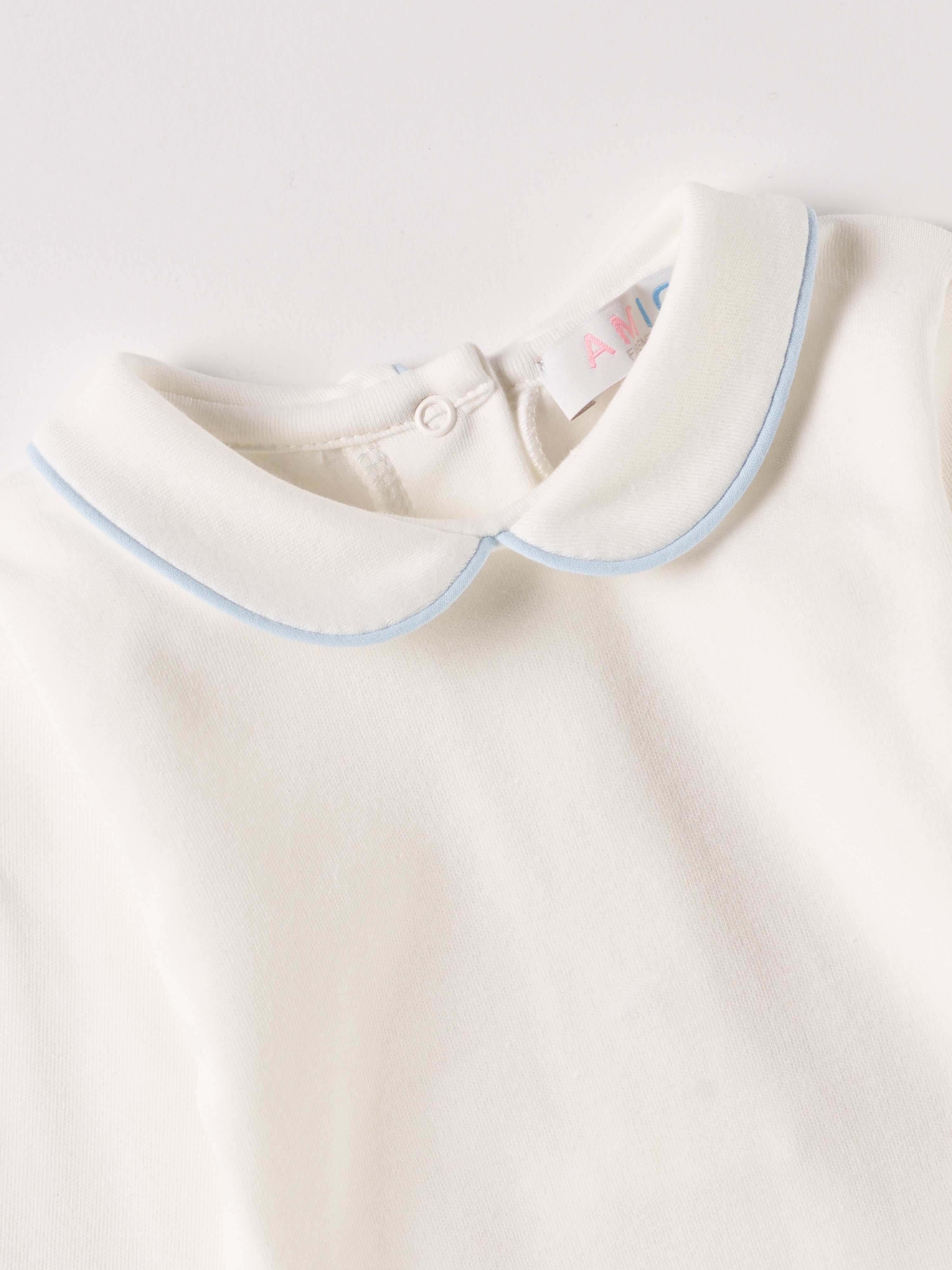 Der langarmige Body, gefertigt aus 100% Baumwolle, hat eine perfekte Passform. Kundinnen und Kunden vertrauen auf unseren Schnitt, da die flachen Druckknöpfe an der Rückseite ein unkompliziertes und schnelles Anziehen ermöglichen. Die "flanellartige" Innenseite wurde speziell für zarte Kinderhaut konzipiert und bietet ein besonders sanftes Trageerlebnis. Ein großer Vorteil der flanellartigen Innenseite ist, dass die Kinder weniger schwitzen. Der Kragen verleiht dem Body ein edles Design.