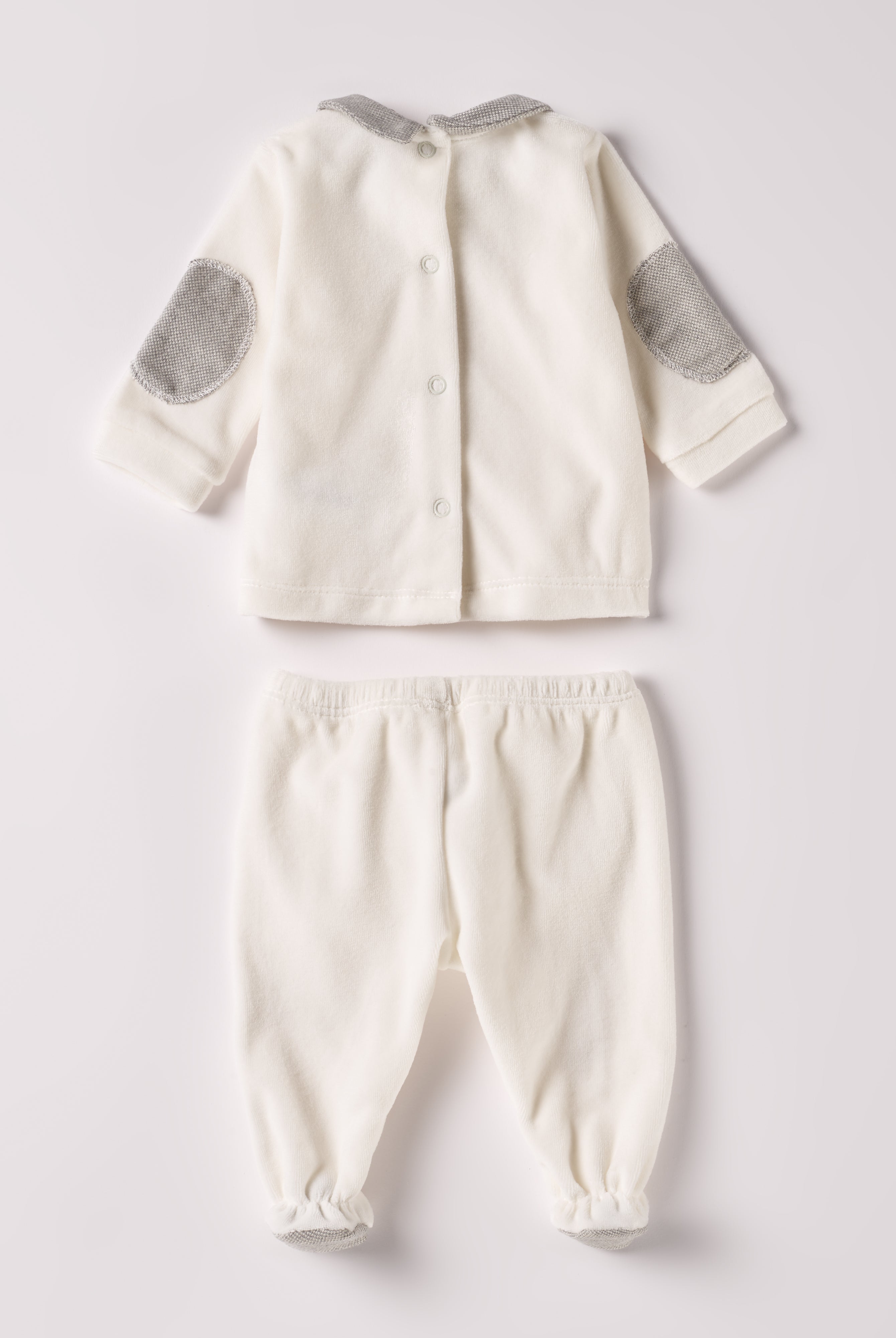 Der weiche und wärmespendende Zweiteiler von AMIO Firenze mit grauem Kragen und Ellbogen Patches ist der perfekte Begleiter für den Alltag in der kalten Jahreszeit. Maximaler Tragekomfort, gepaart mit einer herausragenden Passform aus Samt (Ciniglia). Das Modell hat einen praktischen Schnitt, um etwa die Windel schnell und unkompliziert wechseln zu können. Das Set aus Oberteil und Hose ist vielseitig kombinierbar. Die echten Perlmuttknöpfe verleihen dem Zweiteiler eine besonders elegante Note.