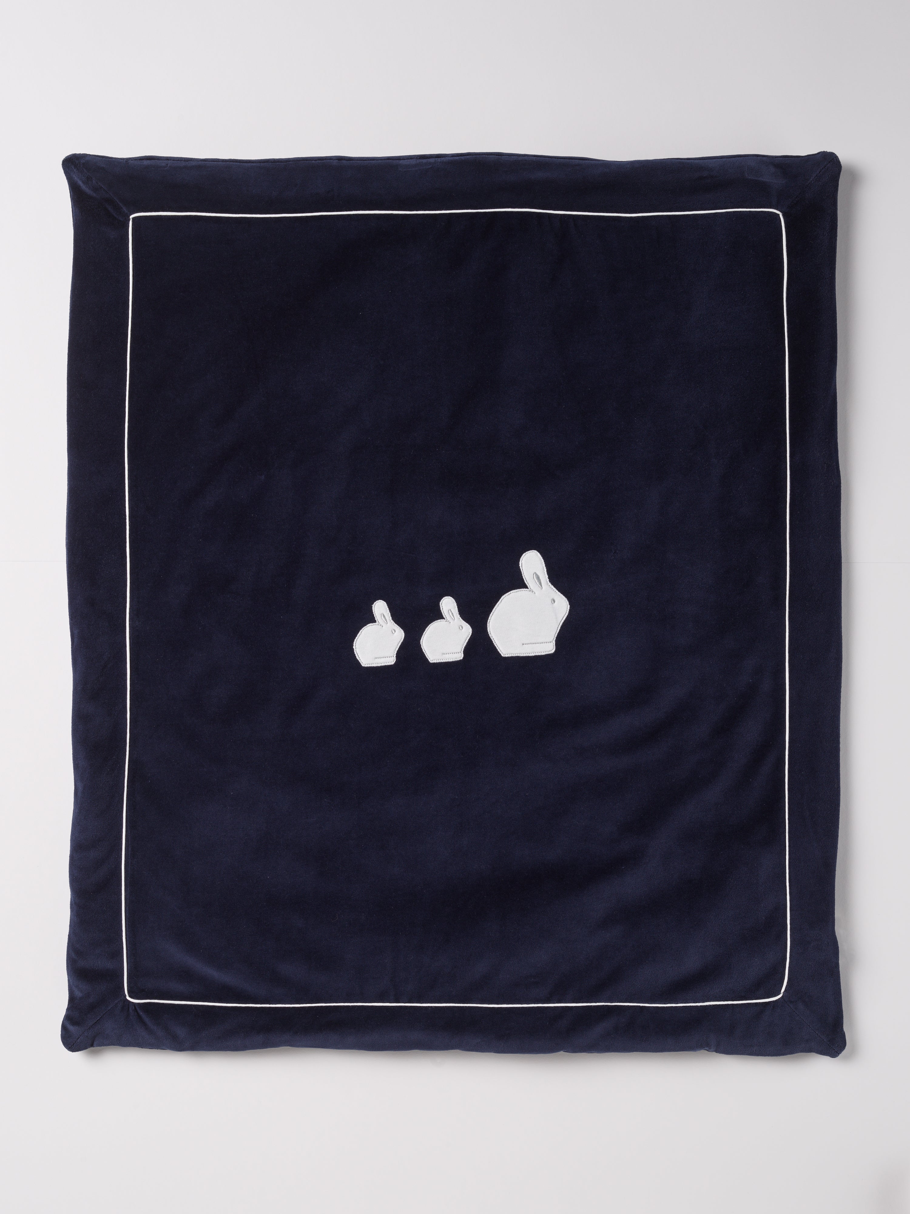 Die praktische Decke hat eine entnehmbare Innendecke, sodass man sowohl eine leichte Sommer- als auch eine warme Winterdecke in einem hat. Die kuschelig weiche Außenseite in Samtqualität ist besonders angenehm an der Haut. Das edle Design wird durch eine bezaubernde Applikation aus drei weißen Hasen unterstrichen, die jedes Baby-Zimmer oder jeden Kinderwagen in einen gemütlichen und stilvollen Rückzugsort verwandelt.