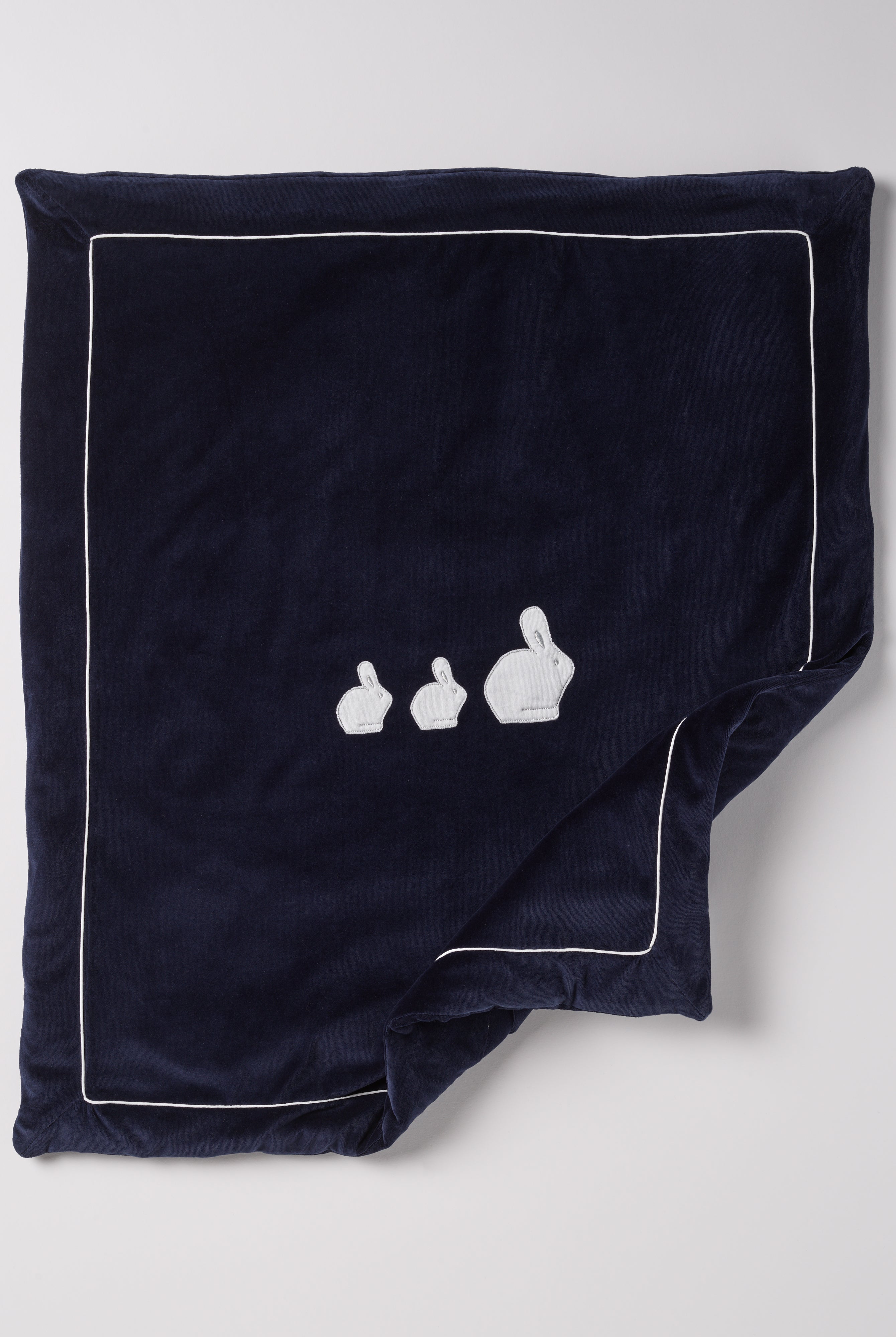 Die praktische Decke hat eine entnehmbare Innendecke, sodass man sowohl eine leichte Sommer- als auch eine warme Winterdecke in einem hat. Die kuschelig weiche Außenseite in Samtqualität ist besonders angenehm an der Haut. Das edle Design wird durch eine bezaubernde Applikation aus drei weißen Hasen unterstrichen, die jedes Baby-Zimmer oder jeden Kinderwagen in einen gemütlichen und stilvollen Rückzugsort verwandelt.