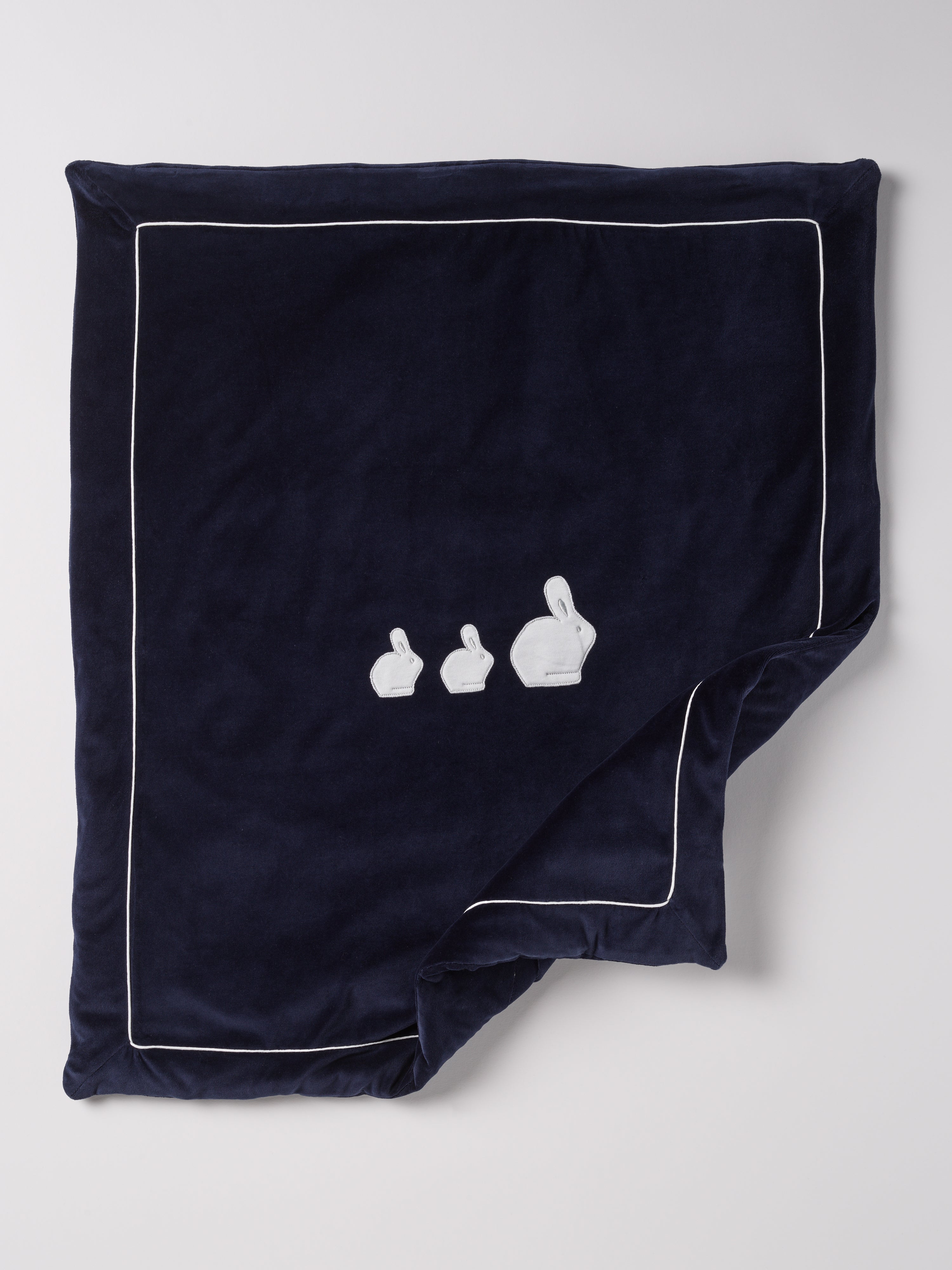 Die praktische Decke hat eine entnehmbare Innendecke, sodass man sowohl eine leichte Sommer- als auch eine warme Winterdecke in einem hat. Die kuschelig weiche Außenseite in Samtqualität ist besonders angenehm an der Haut. Das edle Design wird durch eine bezaubernde Applikation aus drei weißen Hasen unterstrichen, die jedes Baby-Zimmer oder jeden Kinderwagen in einen gemütlichen und stilvollen Rückzugsort verwandelt.