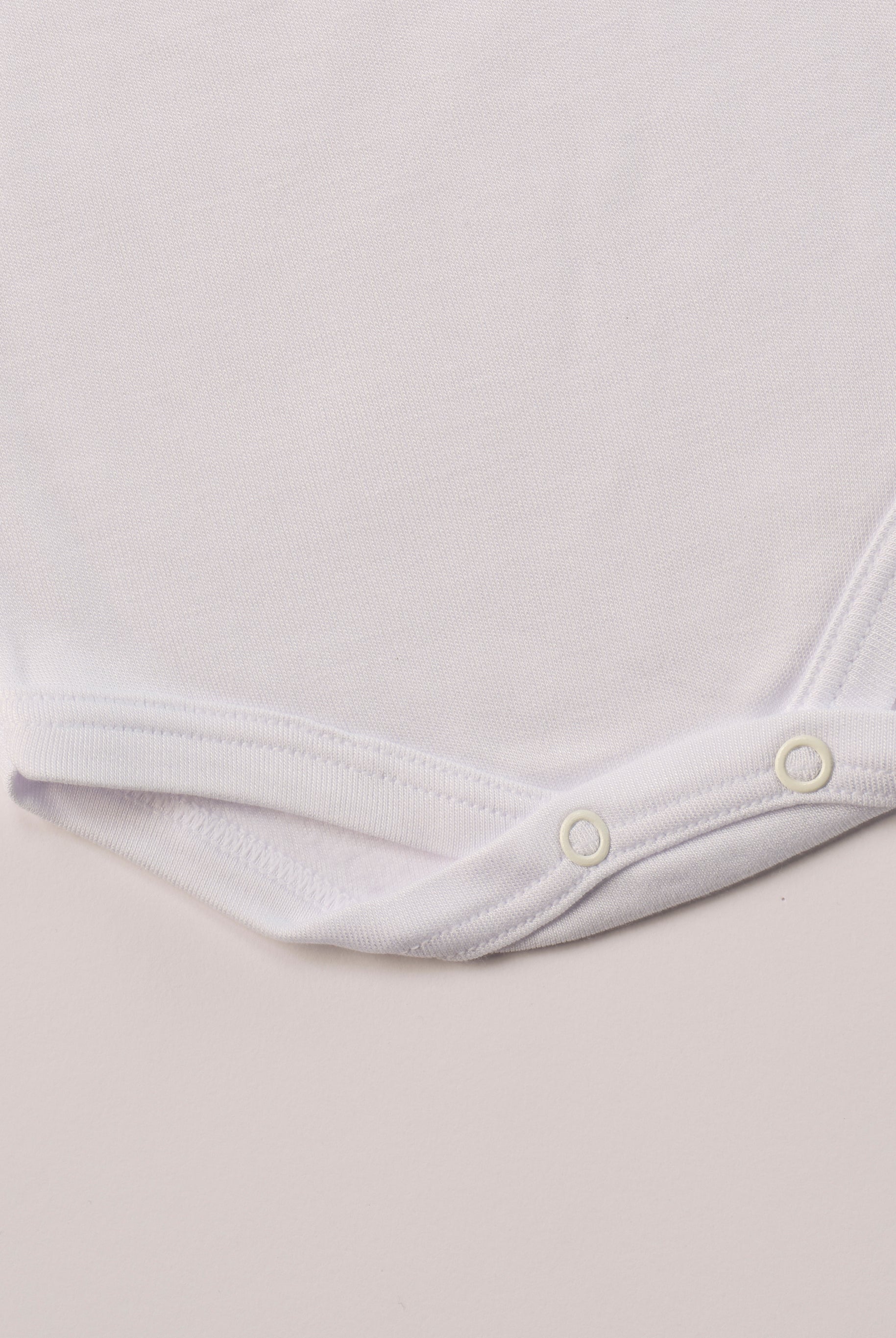 Für besonders sensible Babyhaut. Dieser weiße Amerciano Body besteht aus hochwertiger Bambusviskose — einem Material, das für seine seidige Weichheit, hohe Atmungsaktivität und temperaturausgleichenden Eigenschaften bekannt ist. Sanft zur Haut, funktional im Alltag.