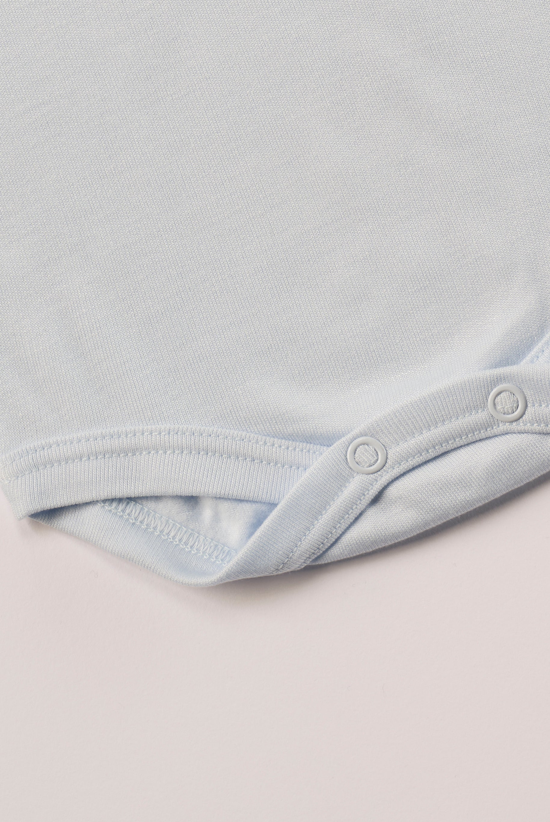 Für besonders sensible Babyhaut. Dieser himmelblaue Amerciano Body besteht aus hochwertiger Bambusviskose — einem Material, das für seine seidige Weichheit, hohe Atmungsaktivität und temperaturausgleichenden Eigenschaften bekannt ist. Sanft zur Haut, funktional im Alltag.