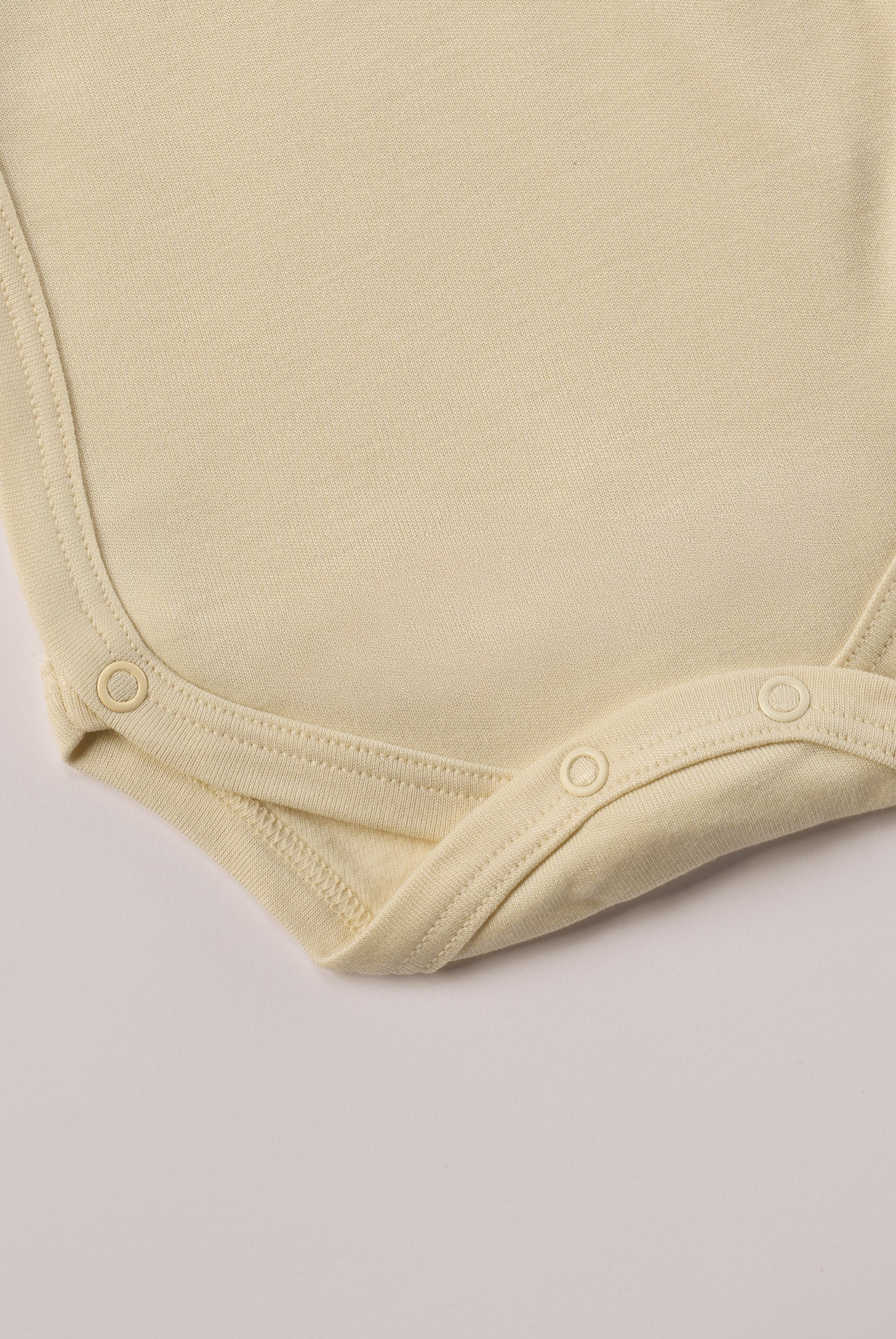 Für besonders sensible Babyhaut. Diese Wickelbodys in weiß und beige für Frühchen besteht aus hochwertiger Bambusviskose — einem Material, das für seine seidige Weichheit, hohe Atmungsaktivität und temperaturausgleichenden Eigenschaften bekannt ist. Sanft zur Haut, funktional im Alltag.