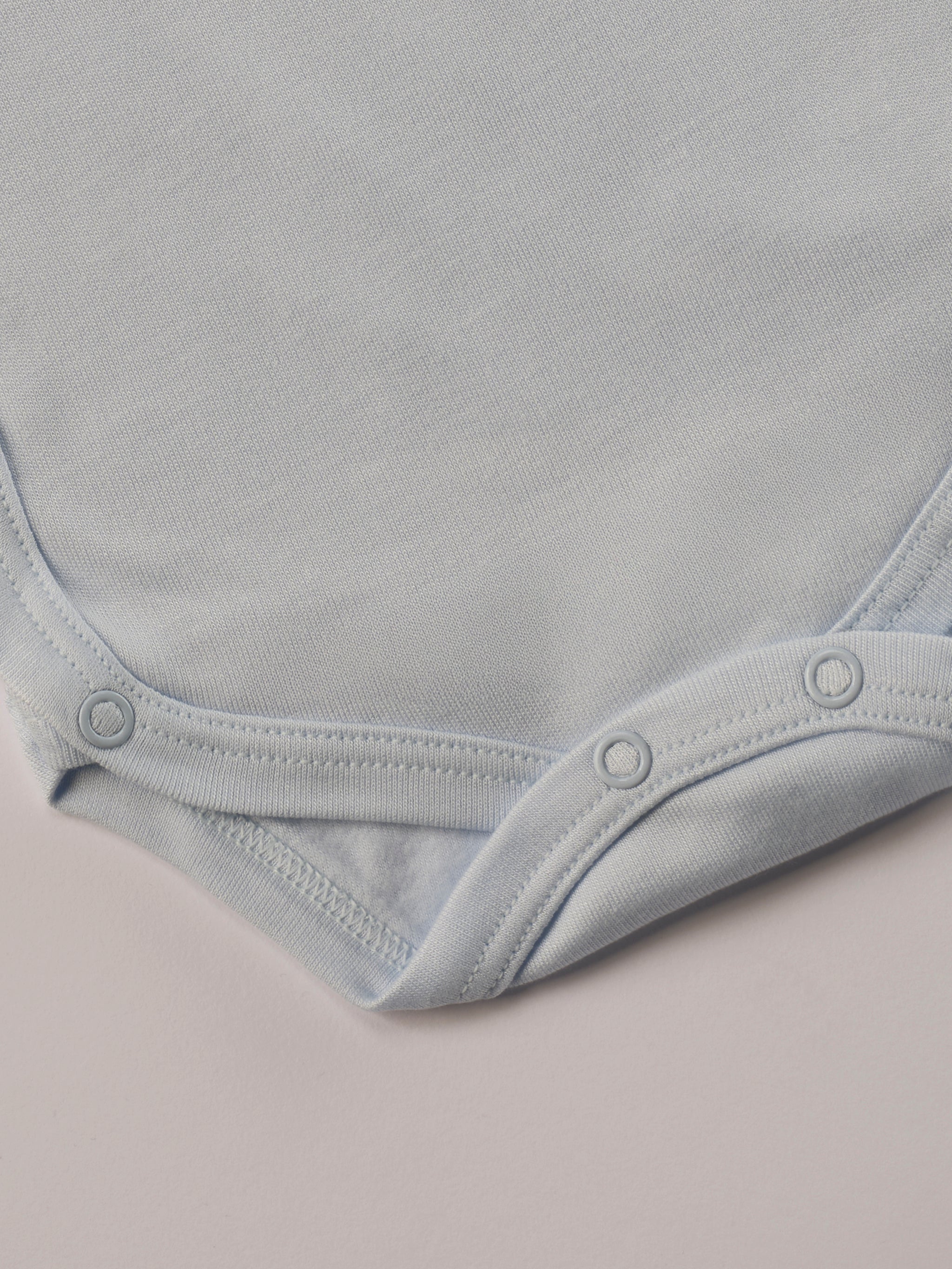 Für besonders sensible Babyhaut. Dieser himmelblaue Wickelbody für Frühchen besteht aus hochwertiger Bambusviskose — einem Material, das für seine seidige Weichheit, hohe Atmungsaktivität und temperaturausgleichenden Eigenschaften bekannt ist. Sanft zur Haut, funktional im Alltag.