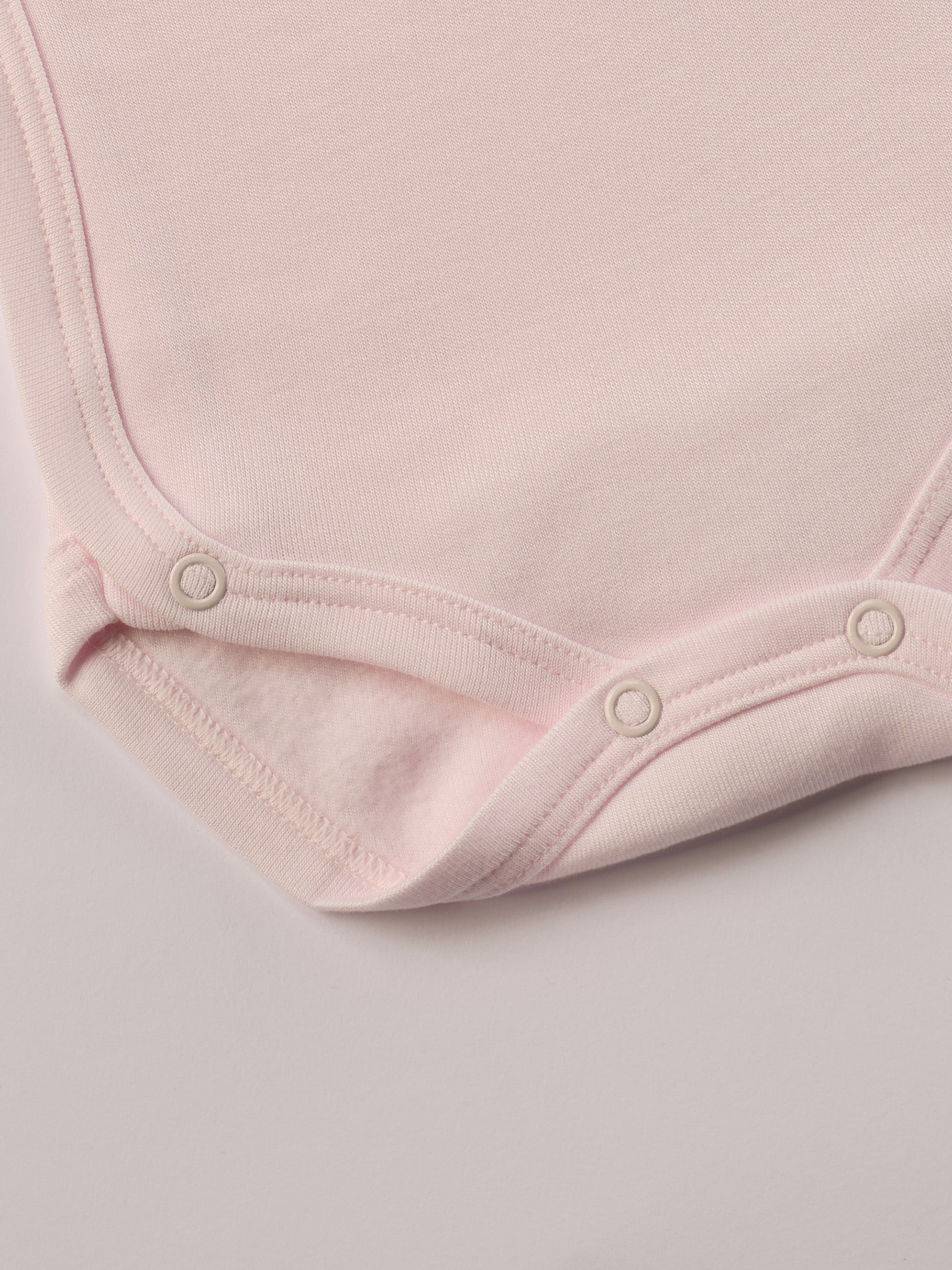 Für besonders sensible Babyhaut. Dieser rosa Wickelbody für Frühchen besteht aus hochwertiger Bambusviskose — einem Material, das für seine seidige Weichheit, hohe Atmungsaktivität und temperaturausgleichenden Eigenschaften bekannt ist. Sanft zur Haut, funktional im Alltag.