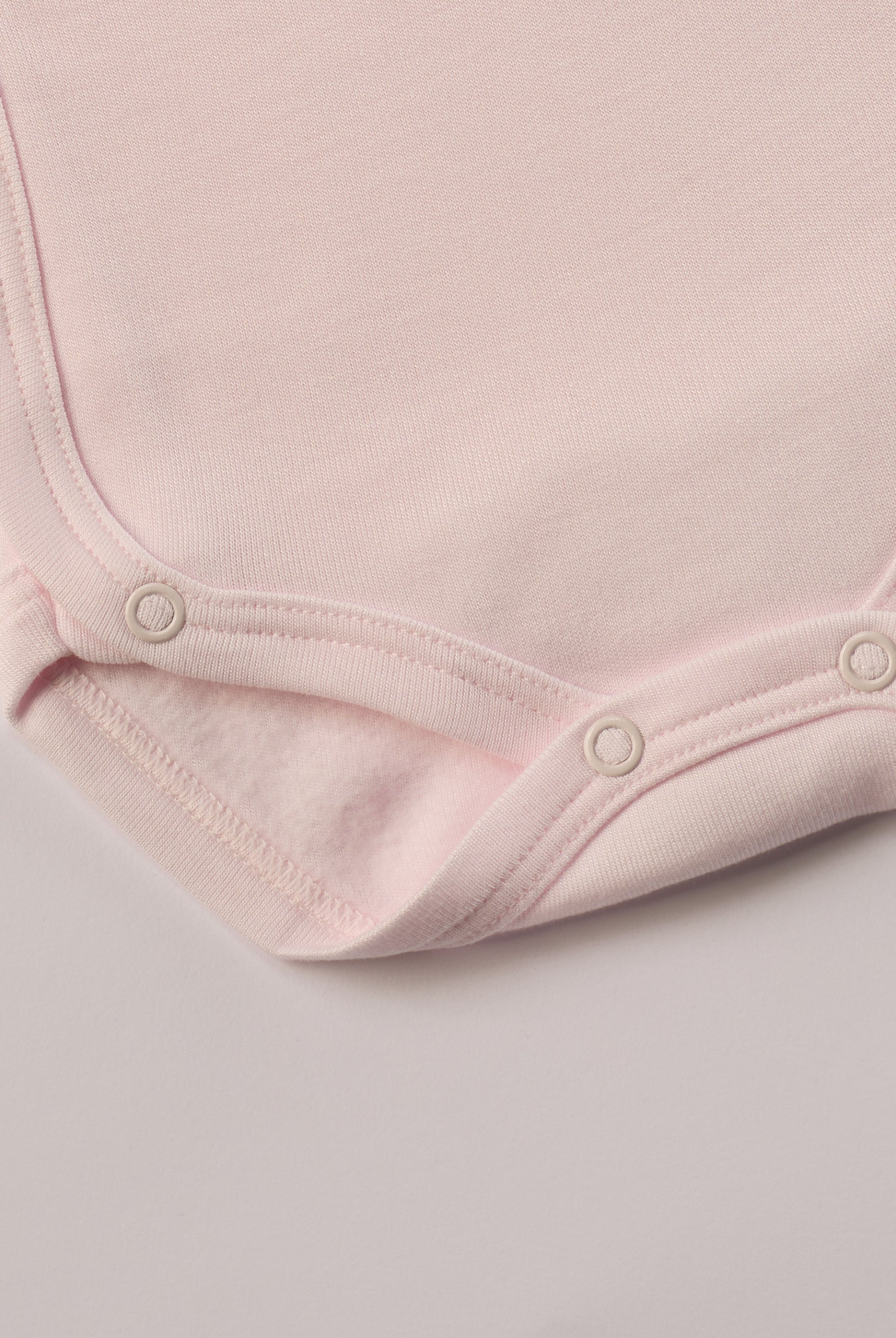 Für besonders sensible Babyhaut. Diese Wickelbodys in weiß und rosa für Frühchen besteht aus hochwertiger Bambusviskose — einem Material, das für seine seidige Weichheit, hohe Atmungsaktivität und temperaturausgleichenden Eigenschaften bekannt ist. Sanft zur Haut, funktional im Alltag.