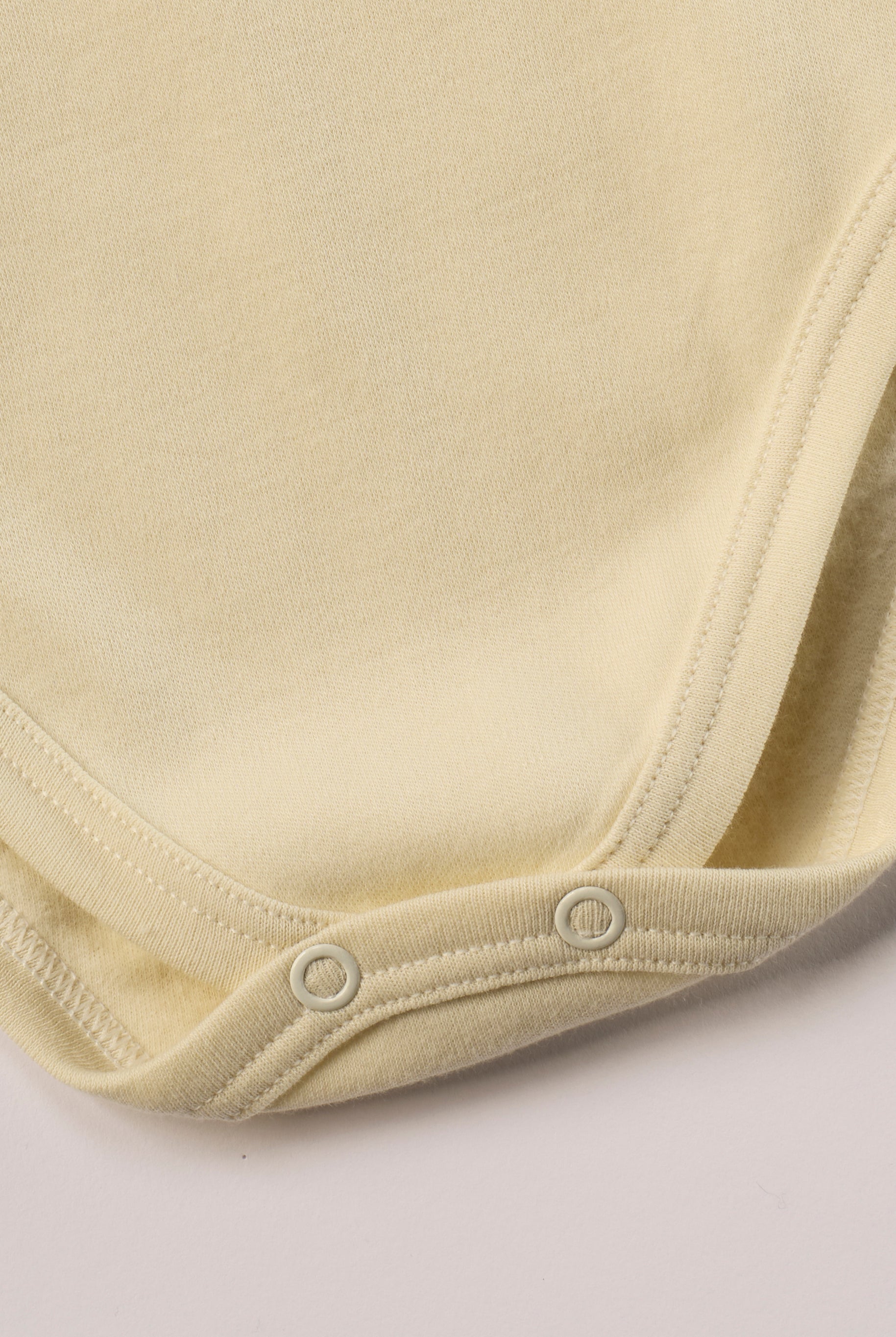 Dieser beige Stehkragenbody besteht aus hochwertiger, sorgfältig veredelter organischer Baumwolle. Die Stoffe sind sanft gefärbt und gebleicht unter Einhaltung strenger EU-Standards. Die nickelfreien Druckknöpfe an der Schulterpartie machen das An- und Ausziehen unkompliziert und schnell.
Innen sorgt die weich angeraute Oberfläche für angenehme Wärme, Feuchtigkeitsaufnahme und ein sanftes Hautgefühl. Der schützende Stehkragen hält den empfindlichen Halsbereich warm und reduziert Zugluft.