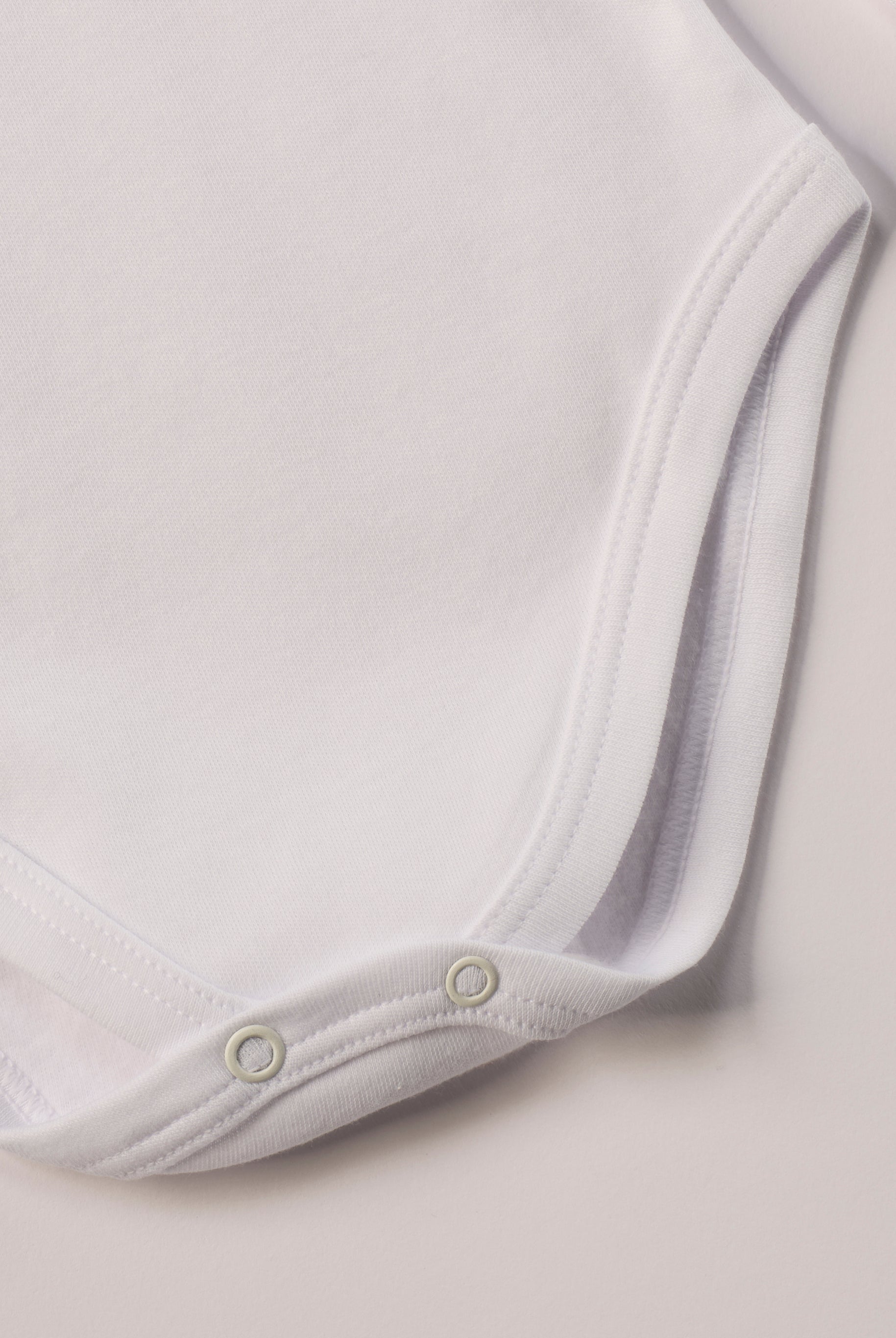 Dieser weiße Stehkragenbody besteht aus hochwertiger, sorgfältig veredelter Baumwolle. Die Stoffe sind sanft gefärbt und gebleicht unter Einhaltung strenger EU-Standards. Die nickelfreien Druckknöpfe an der Schulterpartie machen das An- und Ausziehen unkompliziert und schnell.
Innen sorgt die weich angeraute Oberfläche für angenehme Wärme, Feuchtigkeitsaufnahme und ein sanftes Hautgefühl. Der schützende Stehkragen hält den empfindlichen Halsbereich warm und reduziert Zugluft – ideal für Alltag oder Kita.