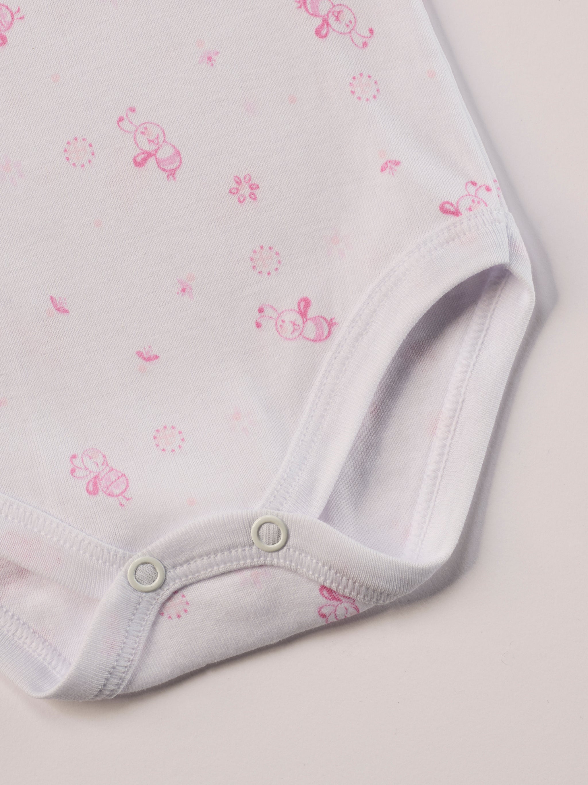 Manchmal darf es praktisch, pflegeleicht und farbenfroh sein – ohne auf Sicherheit und Qualität zu verzichten.
Feiner Stoff für warme Sommertage oder auch als leichte Unterwäsche.
Dieser weiße Body mit rosa Bienen, dezenten Schleifchen und edlen Paspeln am Ausschnitt besteht aus hochwertiger, sorgfältig veredelter organischer Baumwolle. Die Stoffe sind sanft gefärbt und gebleicht unter Einhaltung strenger EU-Standards. Die nickelfreien Druckknöpfe machen das An- und Ausziehen unkompliziert und schnell.