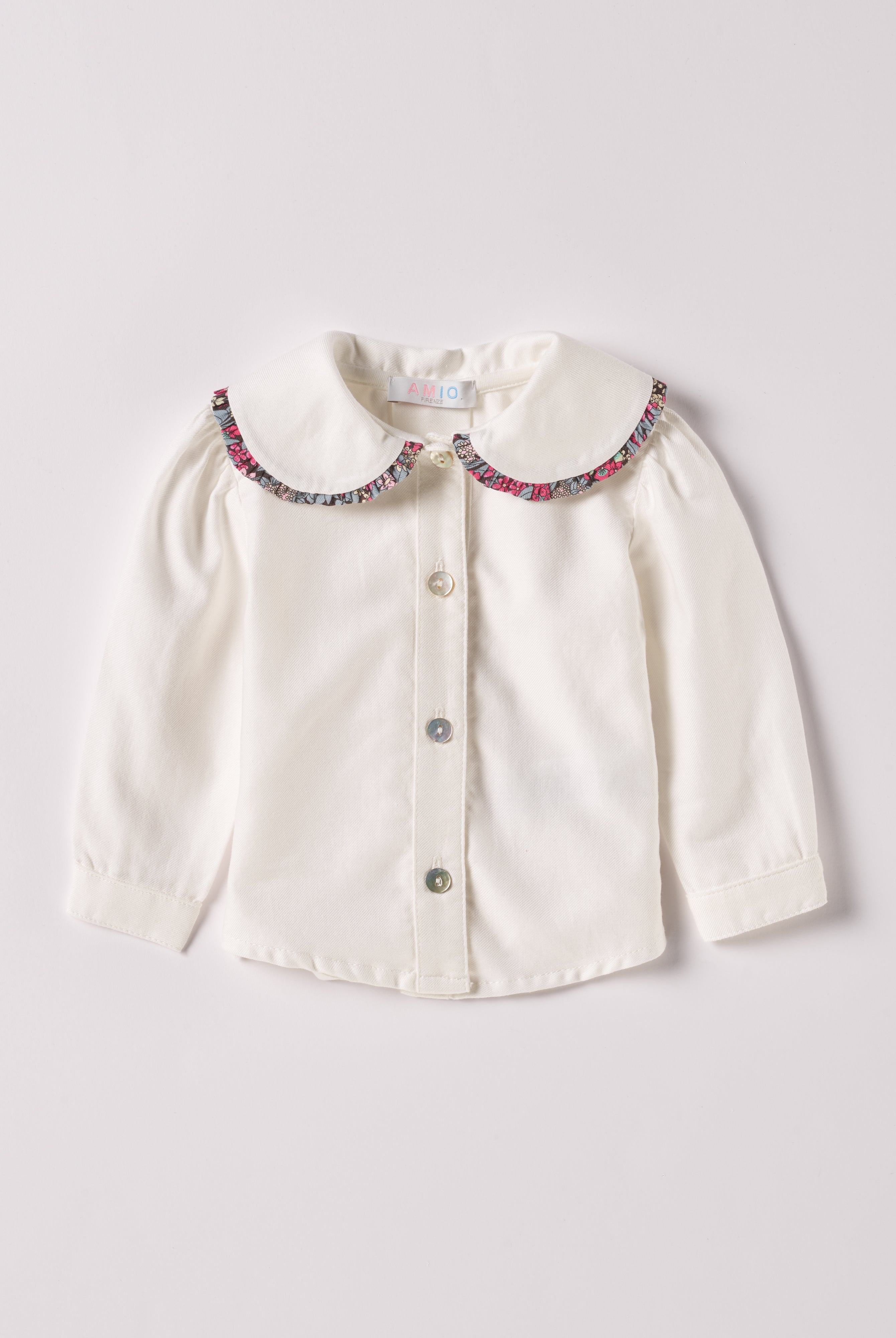 Die cremefarbige Twill-Bluse für Baby Mädchen von AMIO Firenze ist aus weicher Liberty Baumwolle gefertigt und mit einem Peter-Pan-Kragen verziert. Die echten Perlmuttknöpfe verleihen der Bluse eine besonders edle Note. Die floralen Muster des Liberty Stoffes am Kragen haben eine tolle Farbsättigung und machen dieses modische Highlight zu einem echten Blickfang.
Höchste Qualität, bestes Preis-Leistungs-Verhältnis MADE IN ITALY.