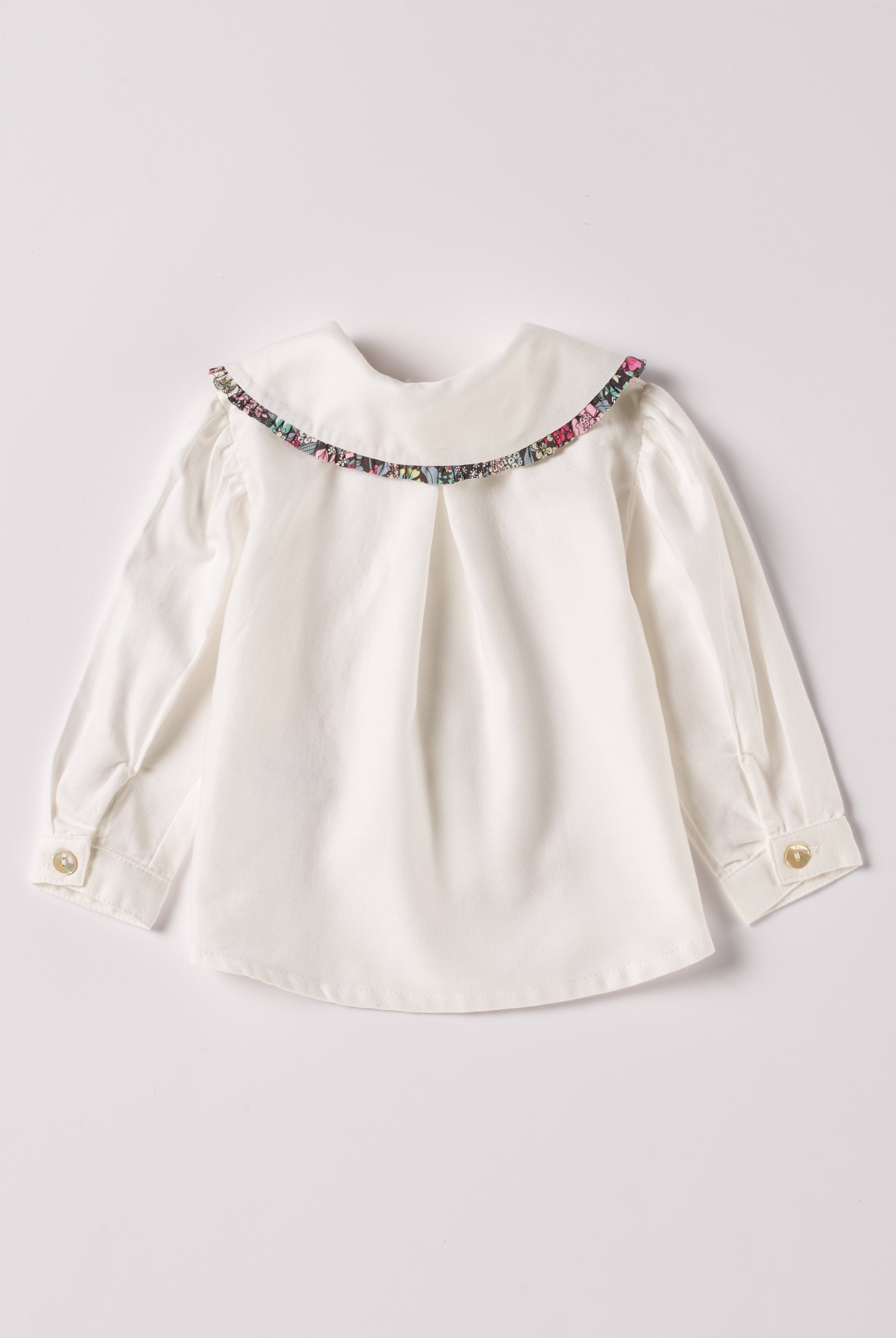 Die cremefarbige Twill-Bluse für Baby Mädchen von AMIO Firenze ist aus weicher Liberty Baumwolle gefertigt und mit einem Peter-Pan-Kragen verziert. Die echten Perlmuttknöpfe verleihen der Bluse eine besonders edle Note. Die floralen Muster des Liberty Stoffes am Kragen haben eine tolle Farbsättigung und machen dieses modische Highlight zu einem echten Blickfang.
Höchste Qualität, bestes Preis-Leistungs-Verhältnis MADE IN ITALY.