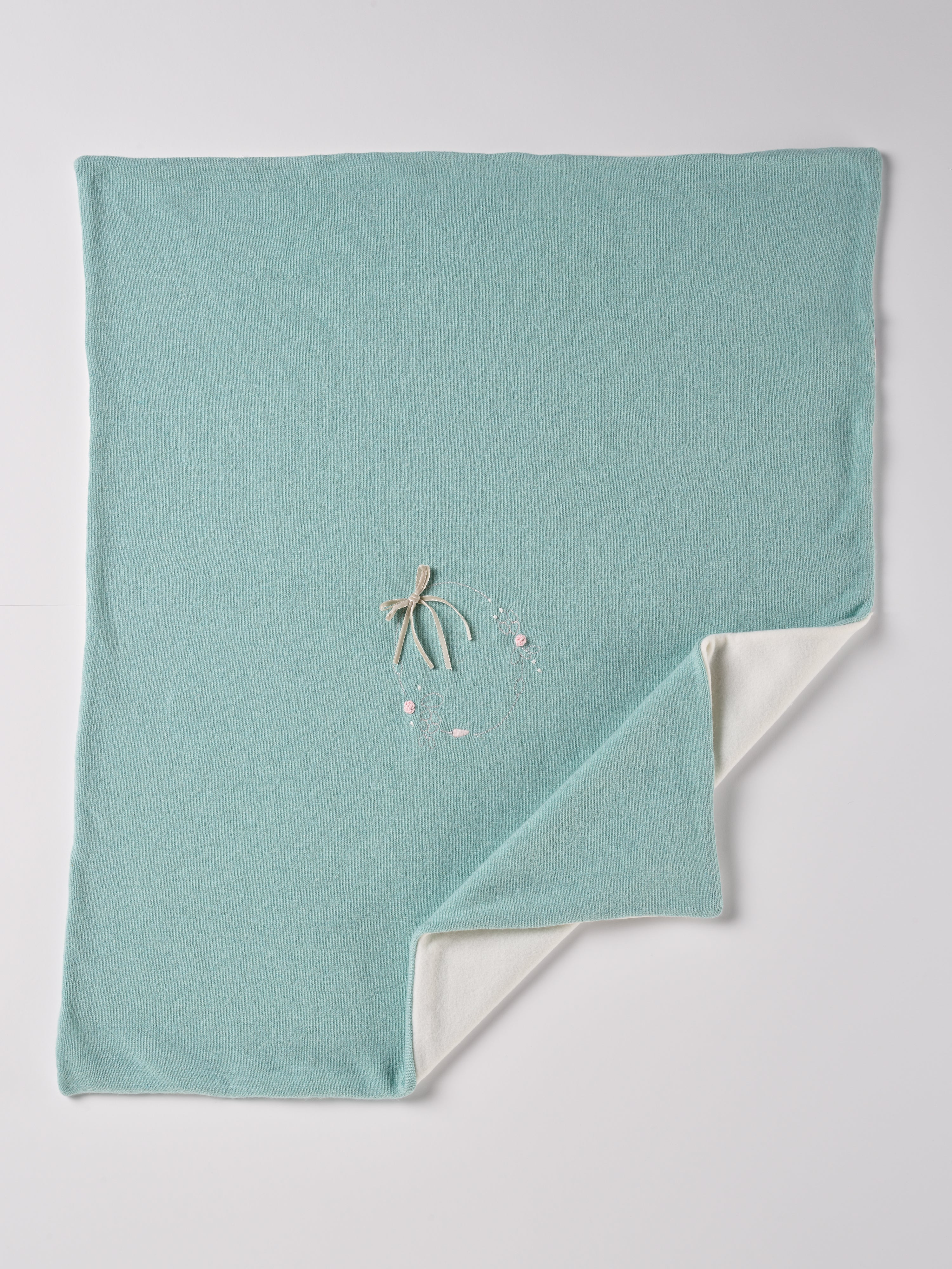 Die elegante gefütterte Strickdecke besticht durch eine feine Handstickerei. Die kuschelig weiche Außenseite ist besonders angenehm an der Haut. Die Rückseite ist aus feinem Fleece. Das edle Design verwandelt jedes Baby-Zimmer oder jeden Kinderwagen in einen gemütlichen und stilvollen Rückzugsort.
Präsentiert in einer eleganten "kofferartigen" Geschenkbox, ist sie auch das ideale Geschenk für werdende Eltern, Babyparties oder besondere Anlässe.