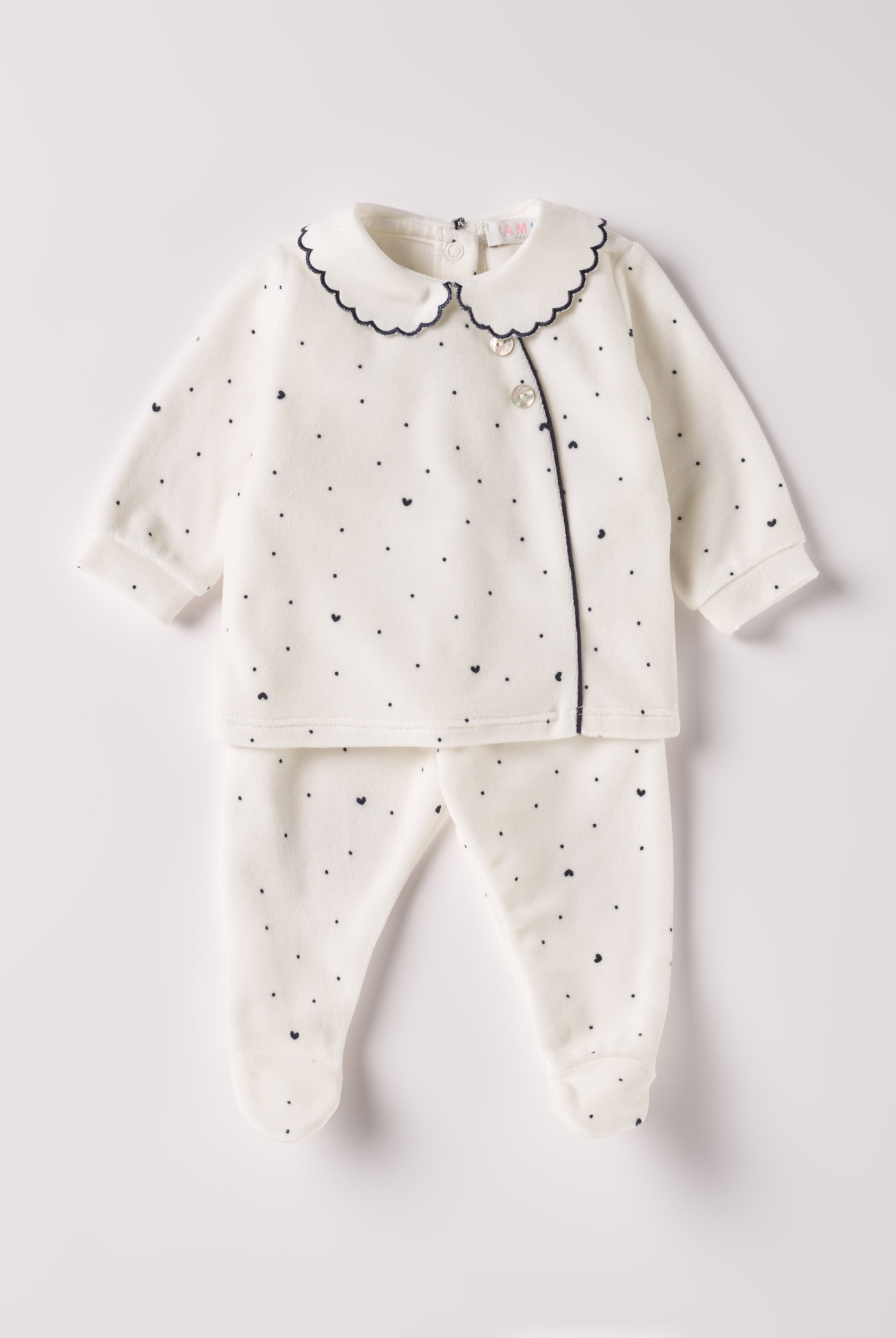 Der weiche und wärmespendende Zweiteiler von AMIO Firenze mit besticktem Kragen und eingewebten Herzen ist der perfekte Begleiter für den Alltag in der kalten Jahreszeit. Die echten Perlmuttknöpfe auf der Vorderseite veredeln den Look. Maximaler Tragekomfort, gepaart mit einer herausragenden Passform aus Samt (Ciniglia). Das Modell hat einen praktischen Schnitt, um etwa die Windel schnell und unkompliziert wechseln zu können. Das Set aus Oberteil und Hose ist vielseitig kombinierbar.