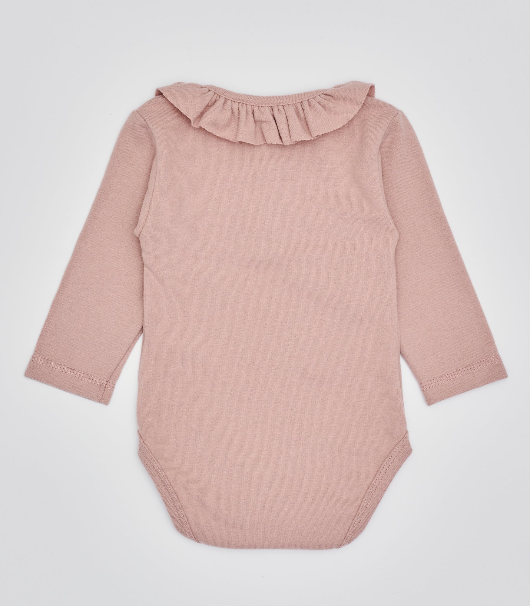 Der langarmige Body hat eine perfekte Passform. Kundinnen und Kunden vertrauen auf unseren Schnitt, da die flachen Knöpfe ein unkompliziertes und schnelles Anziehen ermöglichen. Die "flanellartige" Innenseite wurde speziell für zarte Kinderhaut konzipiert und bietet ein besonders sanftes Trageerlebnis. Ein großer Vorteil der flanellartigen Innenseite ist, dass die Kinder weniger schwitzen. Der Kragen verleiht dem Body ein edles Design, sodass man diesen auch zu besonderen Anlässen tragen kann.