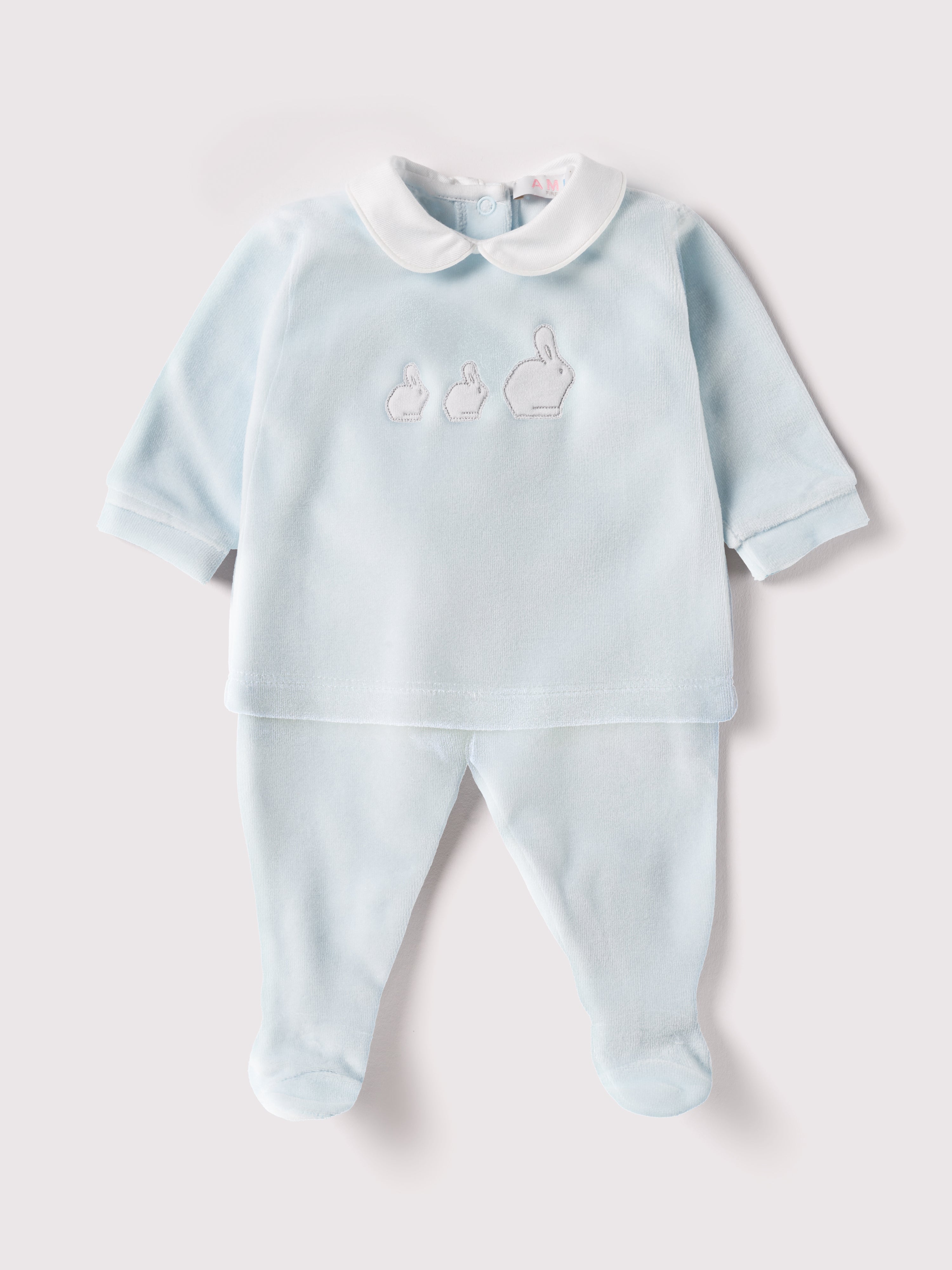 Der weiche und wärmespendende Zweiteiler von AMIO Firenze mit weißem Kragen und Hasenapplikation ist der perfekte Begleiter für den Alltag in der kalten Jahreszeit. Maximaler Tragekomfort, gepaart mit einer herausragenden Passform aus Samt (Ciniglia). Das Modell hat einen praktischen Schnitt, um etwa die Windel schnell und unkompliziert wechseln zu können. Das Set aus Oberteil und Hose ist vielseitig kombinierbar. Ein&nbsp;AMIO Firenze Must-Have für jede Grundausstattung.