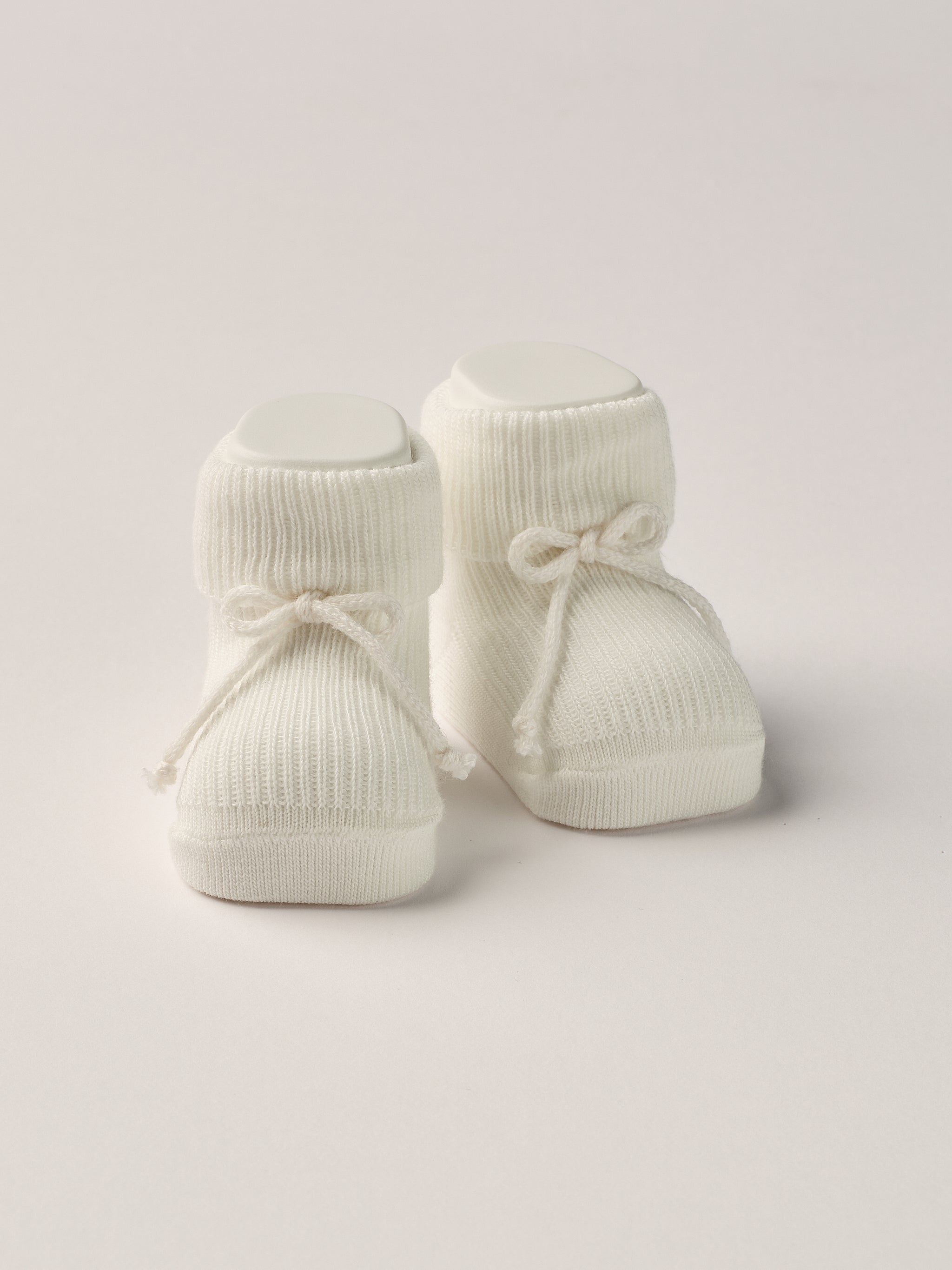 Die creme Baby Booties ähneln klassischen Tennissocken und eignen sich perfekt als Geschenk für Babypartys oder als süße Schwangerschaftsankündigung für Freunde und Verwandte. Die feine Schnürung bietet besonderen Halt am Fuß. Unsere Scarpine werden in einer ansprechenden Geschenkbox präsentiert.&nbsp;

Höchste Qualität, bestes Preis-Leistungs-Verhältnis MADE IN ITALY.