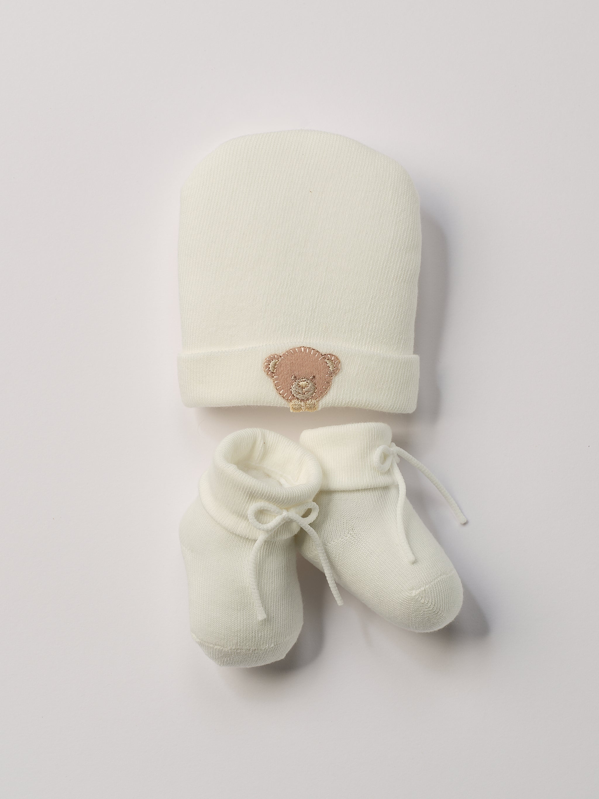 Das niedliche Set von&nbsp;AMIO Firenze ist die perfekte Geschenkidee für Neugeborene. Maximaler Tragekomfort, gepaart mit einer herausragenden Passform. Die feine Schnürung bietet besonderen Halt am Fuß. Die Bärchen-Applikation verleiht der Mütze einen verspielten Look. Das Set wird in einer ansprechenden Geschenkbox präsentiert.&nbsp;

Höchste Qualität, bestes Preis-Leistungs-Verhältnis&nbsp;MADE IN ITALY.