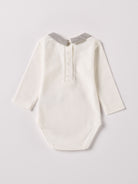 Der langarmige Body, gefertigt aus 100% Baumwolle, hat eine perfekte Passform. Kundinnen und Kunden vertrauen auf unseren Schnitt, da die flachen Knöpfe an der Rückseite ein unkompliziertes und schnelles Anziehen ermöglichen. Die "flanellartige" Innenseite wurde speziell für zarte Kinderhaut konzipiert und bietet ein besonders sanftes Trageerlebnis. Ein großer Vorteil der flanellartigen Innenseite ist, dass die Kinder weniger schwitzen. Der Kragen verleiht dem Body ein edles Design.