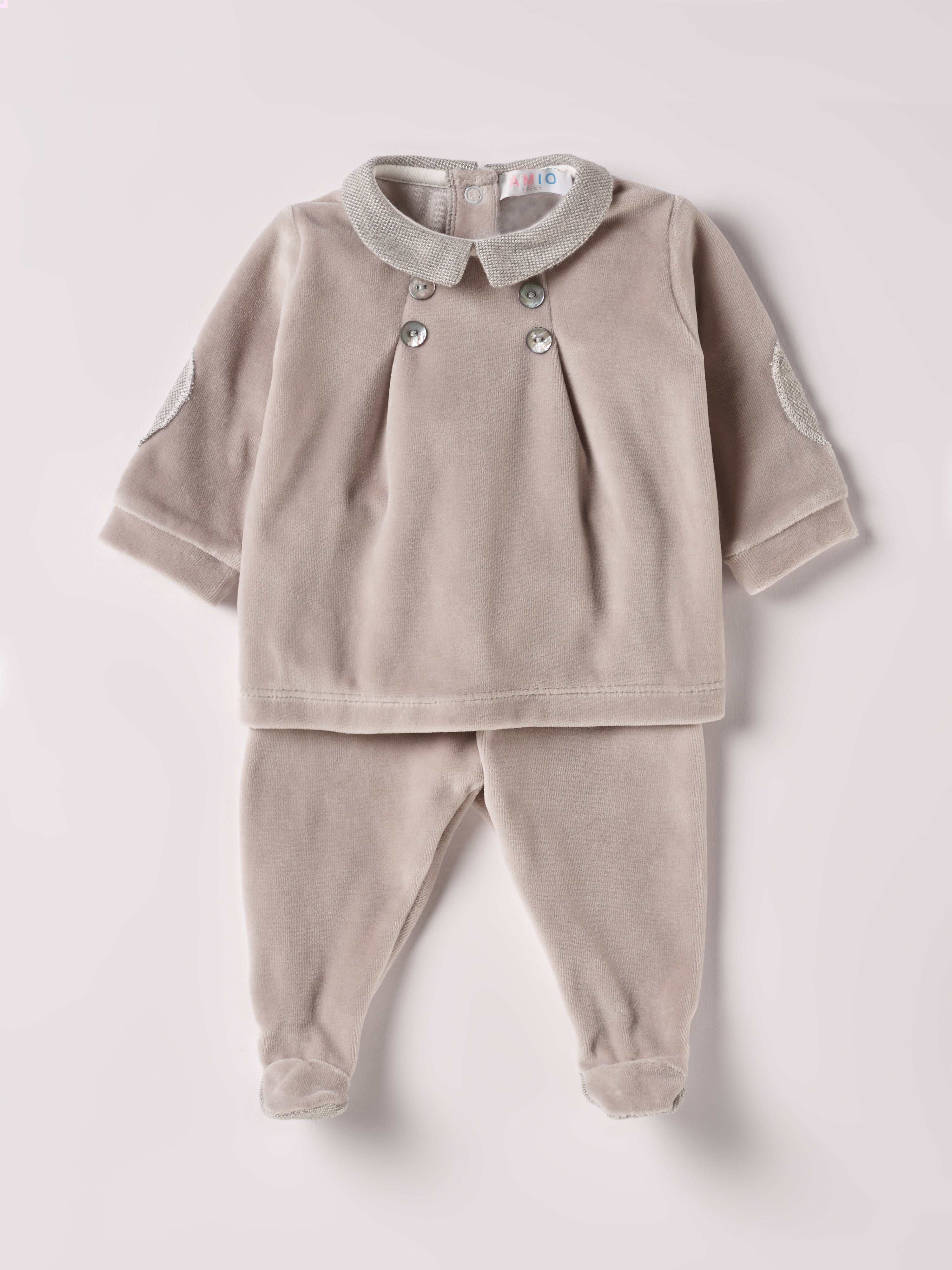 Der weiche und wärmespendende Zweiteiler von AMIO Firenze mit Kragen und Ellbogenpatches ist der perfekte Begleiter für den Alltag in der kalten Jahreszeit. Die echten Perlmuttknöpfe auf der Vorderseite veredeln den Look. Maximaler Tragekomfort, gepaart mit einer herausragenden Passform aus Samt (Ciniglia). Das Set aus Oberteil und Hose ist vielseitig kombinierbar. Das Modell hat einen praktischen Schnitt, um etwa die Windel schnell und unkompliziert wechseln zu können.