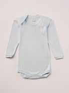 Für besonders sensible Babyhaut. Dieser himmelblaue Amerciano Body besteht aus hochwertiger Bambusviskose — einem Material, das für seine seidige Weichheit, hohe Atmungsaktivität und temperaturausgleichenden Eigenschaften bekannt ist. Sanft zur Haut, funktional im Alltag.