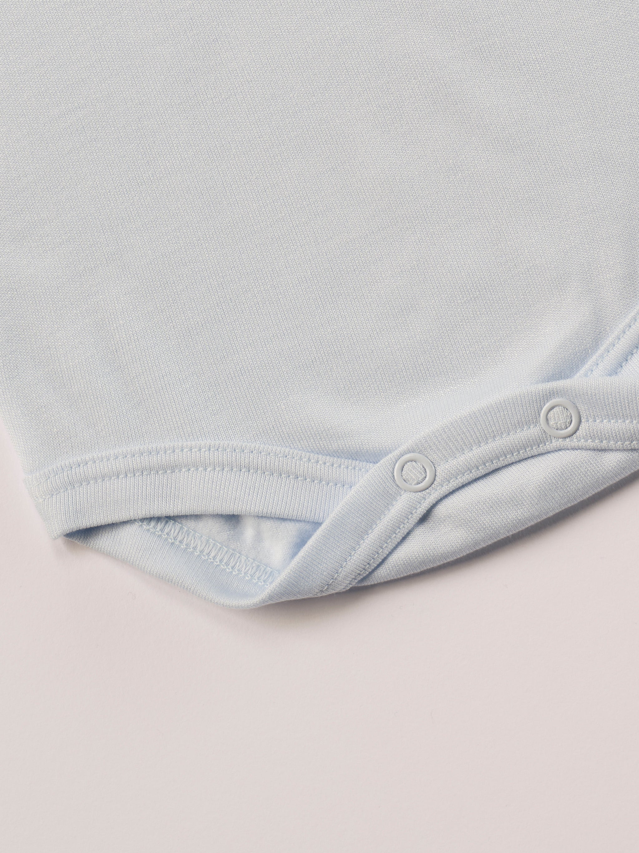 Für besonders sensible Babyhaut. Dieser himmelblaue Amerciano Body besteht aus hochwertiger Bambusviskose — einem Material, das für seine seidige Weichheit, hohe Atmungsaktivität und temperaturausgleichenden Eigenschaften bekannt ist. Sanft zur Haut, funktional im Alltag.