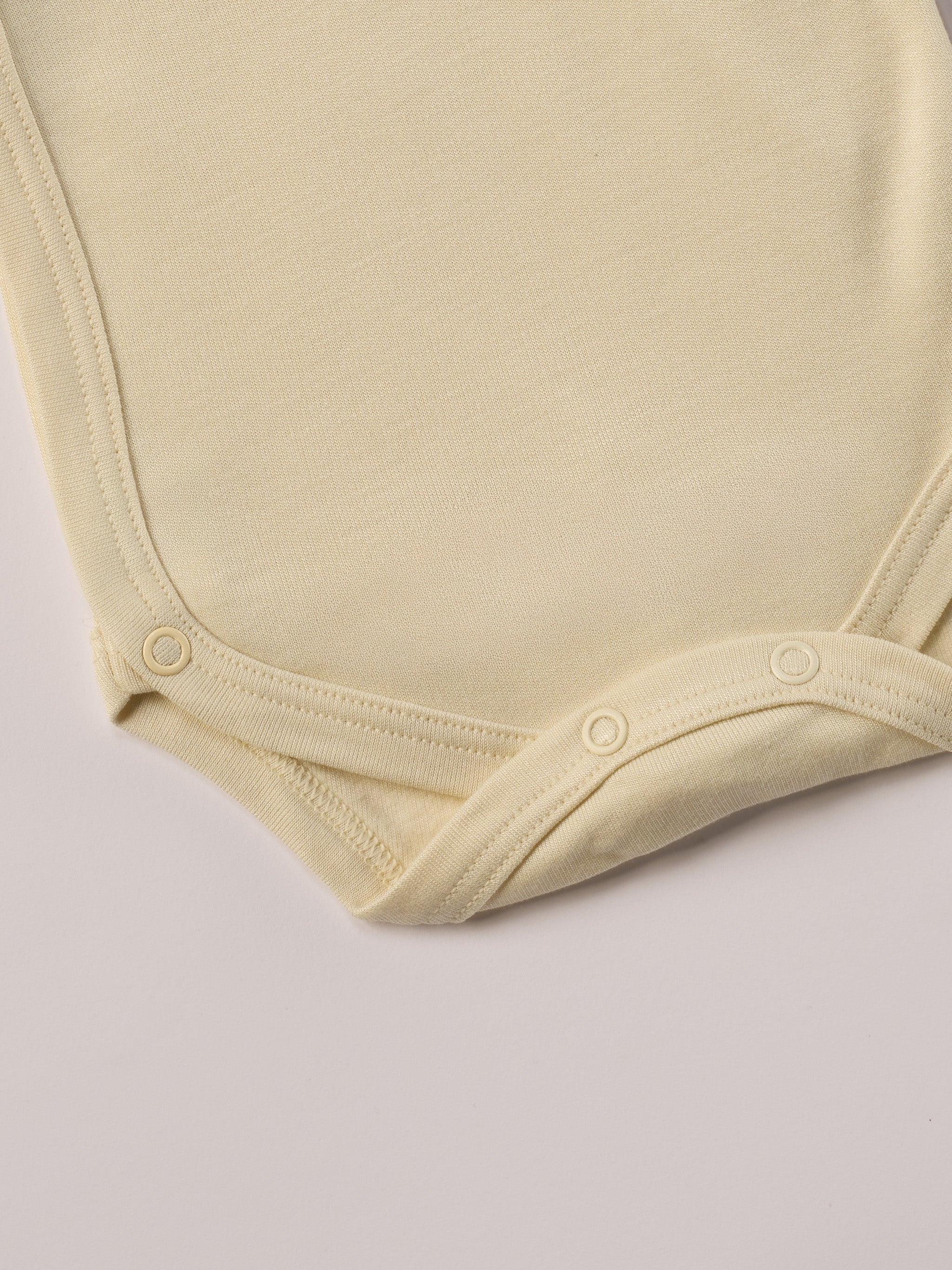 Für besonders sensible Babyhaut. Dieser beige Wickelbody für Frühchen besteht aus hochwertiger Bambusviskose — einem Material, das für seine seidige Weichheit, hohe Atmungsaktivität und temperaturausgleichenden Eigenschaften bekannt ist. Sanft zur Haut, funktional im Alltag.