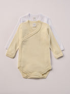 Für besonders sensible Babyhaut. Diese Wickelbodys in weiß und beige bestehen aus hochwertiger Bambusviskose — einem Material, das für seine seidige Weichheit, hohe Atmungsaktivität und temperaturausgleichenden Eigenschaften bekannt ist. Sanft zur Haut, funktional im Alltag.