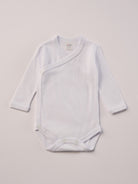 Für besonders sensible Babyhaut. Diese Wickelbodys in weiß und beige bestehen aus hochwertiger Bambusviskose — einem Material, das für seine seidige Weichheit, hohe Atmungsaktivität und temperaturausgleichenden Eigenschaften bekannt ist. Sanft zur Haut, funktional im Alltag.