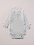 Für besonders sensible Babyhaut. Diese Wickelbodys in weiß und himmelblau bestehen aus hochwertiger Bambusviskose — einem Material, das für seine seidige Weichheit, hohe Atmungsaktivität und temperaturausgleichenden Eigenschaften bekannt ist. Sanft zur Haut, funktional im Alltag.