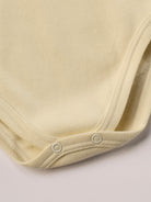 Dieser beige Stehkragenbody besteht aus hochwertiger, sorgfältig veredelter organischer Baumwolle. Die Stoffe sind sanft gefärbt und gebleicht unter Einhaltung strenger EU-Standards. Die nickelfreien Druckknöpfe an der Schulterpartie machen das An- und Ausziehen unkompliziert und schnell.

Innen sorgt die weich angeraute Oberfläche für angenehme Wärme, Feuchtigkeitsaufnahme und ein sanftes Hautgefühl. Der schützende Stehkragen hält den empfindlichen Halsbereich warm und reduziert Zugluft.