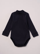 Dieser blaue Stehkragenbody besteht aus hochwertiger, sorgfältig veredelter organischer Baumwolle. Die Stoffe sind sanft gefärbt und gebleicht unter Einhaltung strenger EU-Standards. Die nickelfreien Druckknöpfe an der Schulterpartie machen das An- und Ausziehen unkompliziert und schnell.

Innen sorgt die weich angeraute Oberfläche für angenehme Wärme, Feuchtigkeitsaufnahme und ein sanftes Hautgefühl. Der schützende Stehkragen hält den empfindlichen Halsbereich warm und reduziert Zugluft.