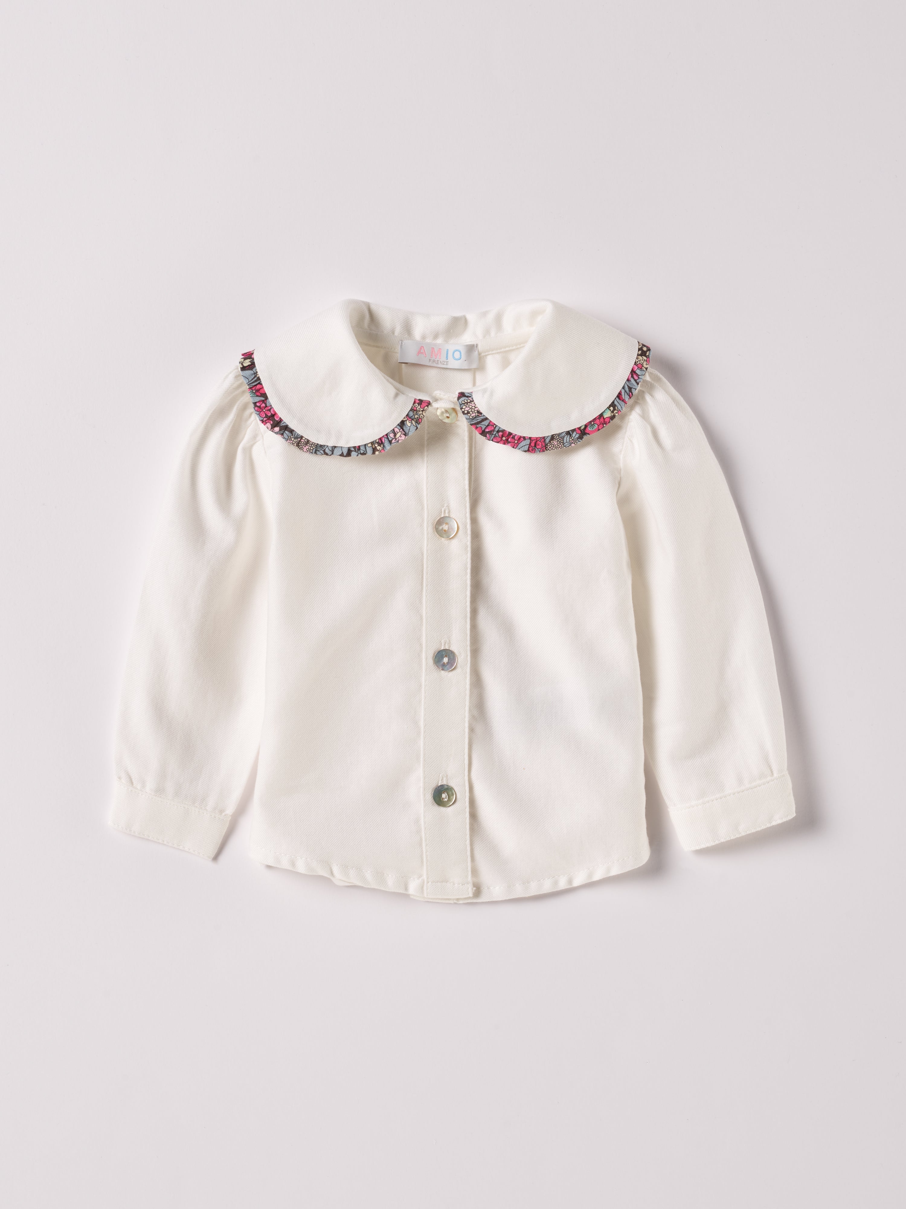 Die cremefarbige Twill-Bluse für Baby Mädchen von AMIO Firenze ist aus weicher Liberty Baumwolle gefertigt und mit einem Peter-Pan-Kragen verziert. Die echten Perlmuttknöpfe verleihen der Bluse eine besonders edle Note. Die floralen Muster des Liberty Stoffes am Kragen haben eine tolle Farbsättigung und machen dieses modische Highlight zu einem echten Blickfang.

Höchste Qualität, bestes Preis-Leistungs-Verhältnis&nbsp;MADE IN ITALY.