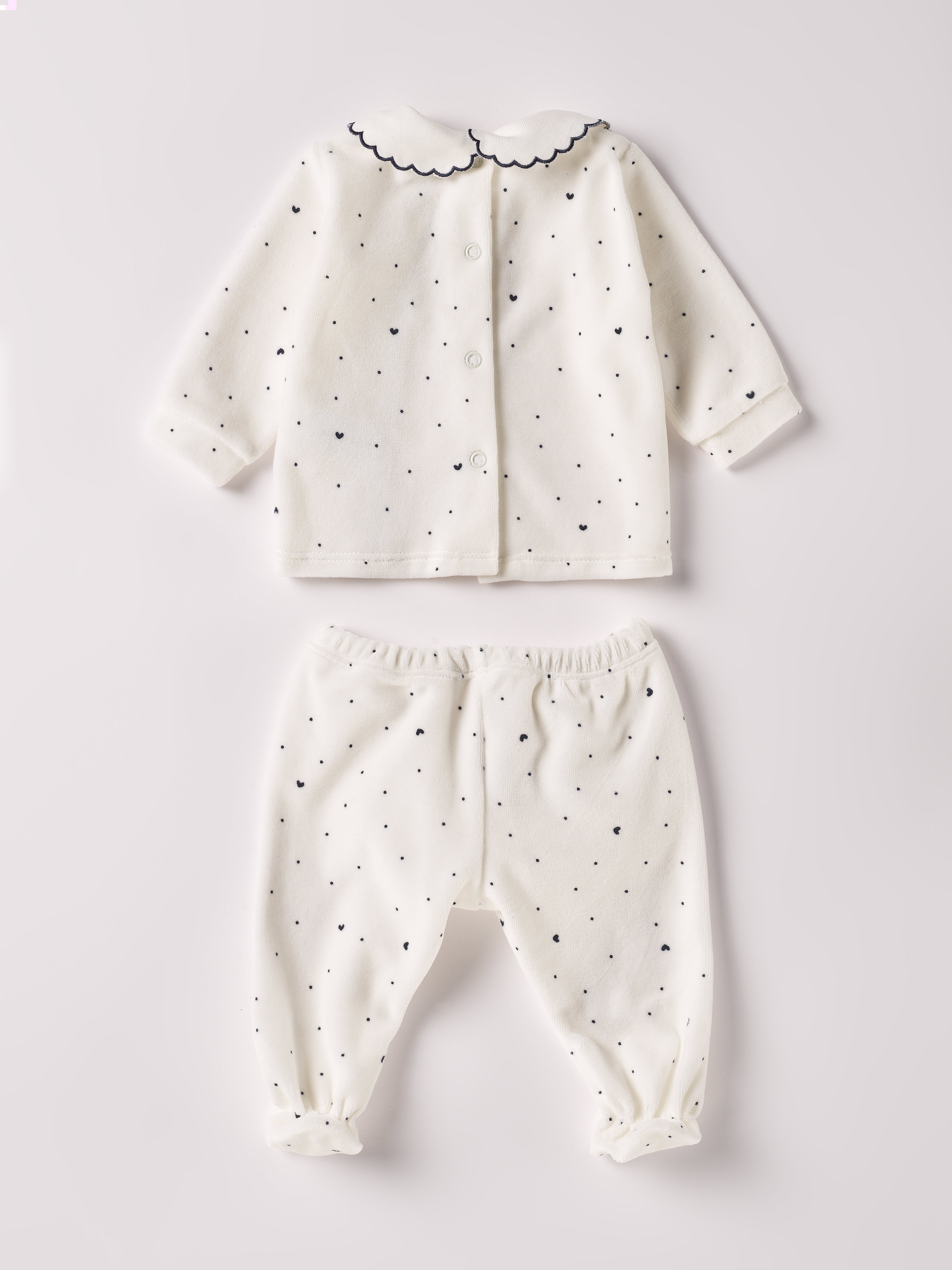 Der weiche und wärmespendende Zweiteiler von AMIO Firenze mit besticktem Kragen und eingewebten Herzen ist der perfekte Begleiter für den Alltag in der kalten Jahreszeit. Die echten Perlmuttknöpfe auf der Vorderseite veredeln den Look. Maximaler Tragekomfort, gepaart mit einer herausragenden Passform aus Samt (Ciniglia). Das Modell hat einen praktischen Schnitt, um etwa die Windel schnell und unkompliziert wechseln zu können. Das Set aus Oberteil und Hose ist vielseitig kombinierbar.