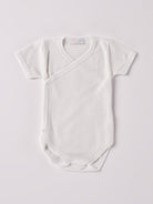 Der kurzarmige Wickelbody, gefertigt aus 70% Bambus und 30% Baumwolle, hat eine perfekte Passform. Kundinnen und Kunden vertrauen auf unseren Schnitt, da dieses Modell ein unkompliziertes und schnelles Anziehen ermöglicht. Ein großer Vorteil der Bambusfaser ist, dass sie wärmeregulierende Eigenschaften hat, sodass die Babys nicht schwitzen. Zudem ist die Bambusfaser allergikerfreundlich. Ein AMIO Firenze Must-Have für jede Grundausstattung.