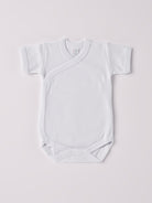 Der kurzarmige Wickelbody, gefertigt aus 100% Baumwolle, hat eine perfekte Passform. Kundinnen und Kunden vertrauen auf unseren Schnitt, da dieses Modell ein unkompliziertes und schnelles Anziehen ermöglicht. Die "flanellartige" Innenseite wurde speziell für zarte Kinderhaut konzipiert und bietet ein besonders sanftes Trageerlebnis. Ein großer Vorteil der flanellartigen Innenseite ist, dass die Kinder weniger schwitzen. Ein AMIO Firenze Must-Have für jede Grundausstattung.