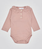 Der langarmige Body hat eine perfekte Passform. Kundinnen und Kunden vertrauen auf unseren Schnitt, da die flachen Knöpfe ein unkompliziertes und schnelles Anziehen ermöglichen. Die "flanellartige" Innenseite wurde speziell für zarte Kinderhaut konzipiert und bietet ein besonders sanftes Trageerlebnis. Ein großer Vorteil der flanellartigen Innenseite ist, dass die Kinder weniger schwitzen. Der Kragen verleiht dem Body ein edles Design, sodass man diesen auch zu besonderen Anlässen tragen kann.